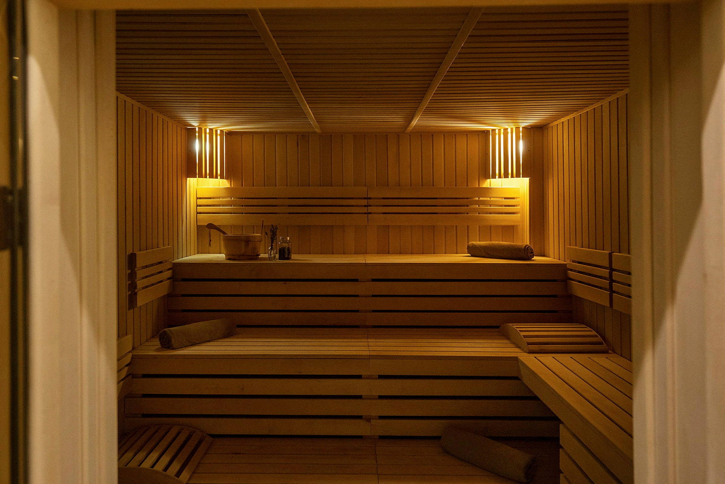 En indendørs sauna med træpaneler og siddebænke. (AI-genereret tekst)