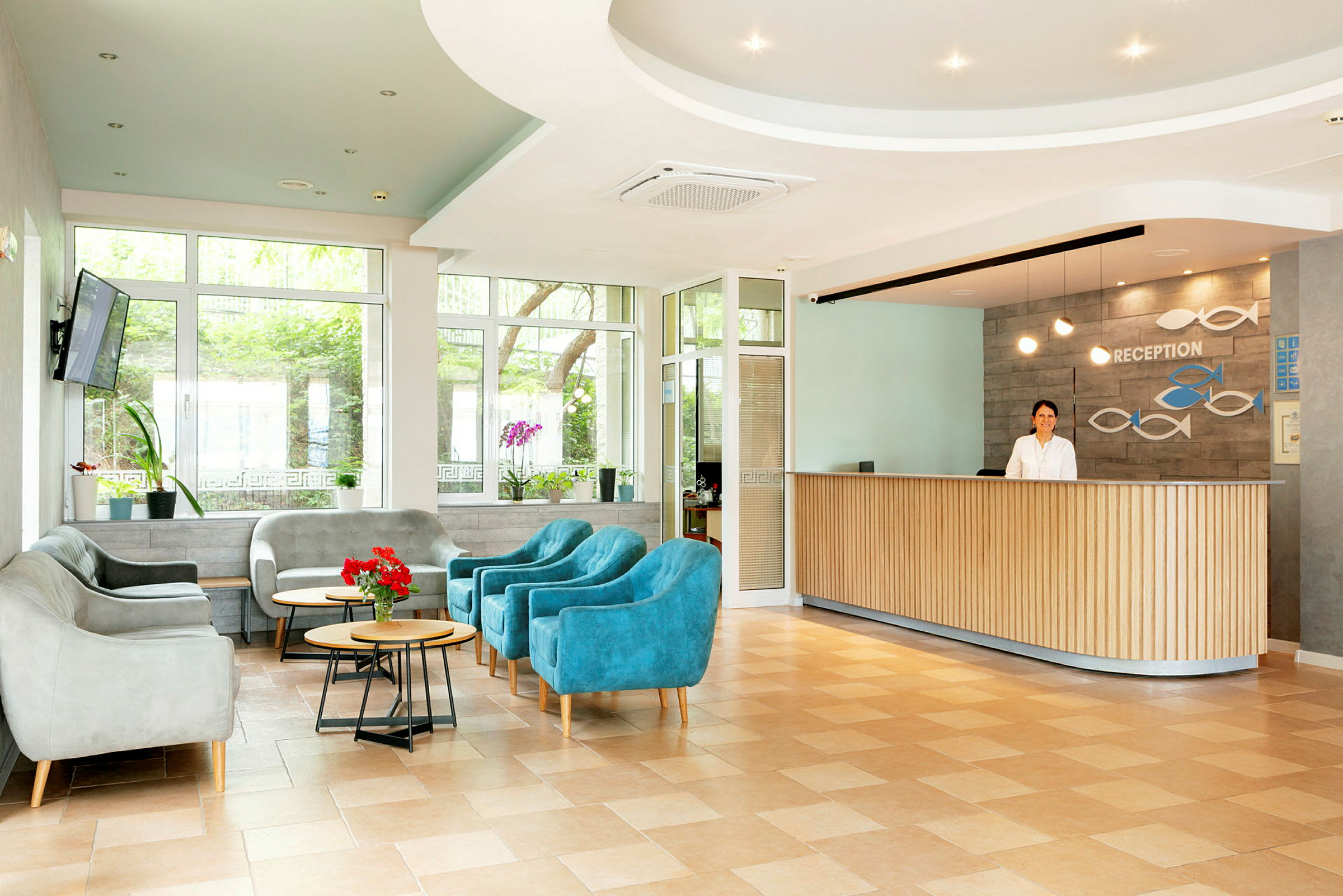 Hotelreception med siddeområde og blomster. (AI-genereret tekst)