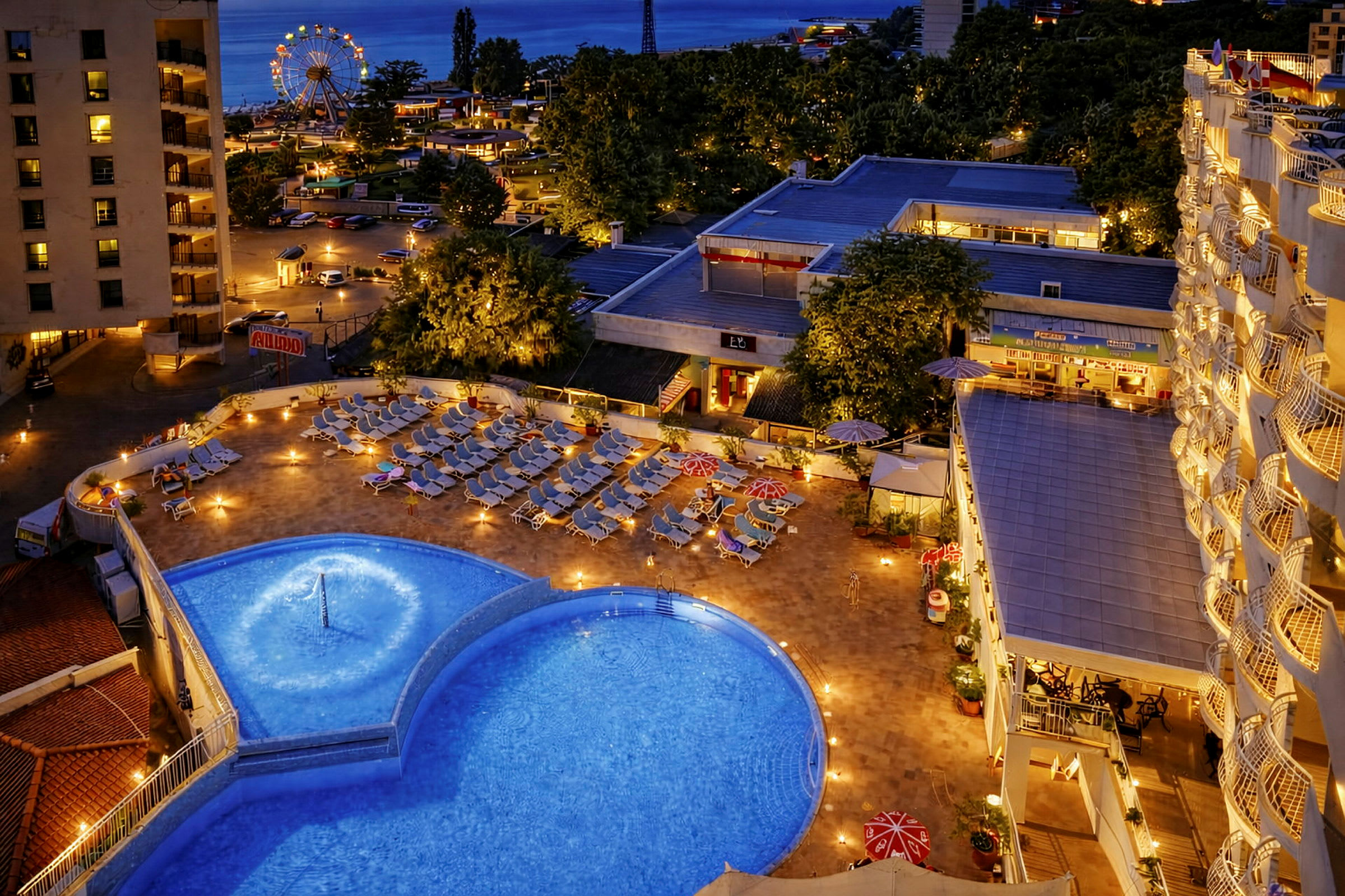 Hotelområde med pool og solsenge, omkringliggende bygninger og et oplyst pariserhjul i baggrunden. (AI-genereret tekst)