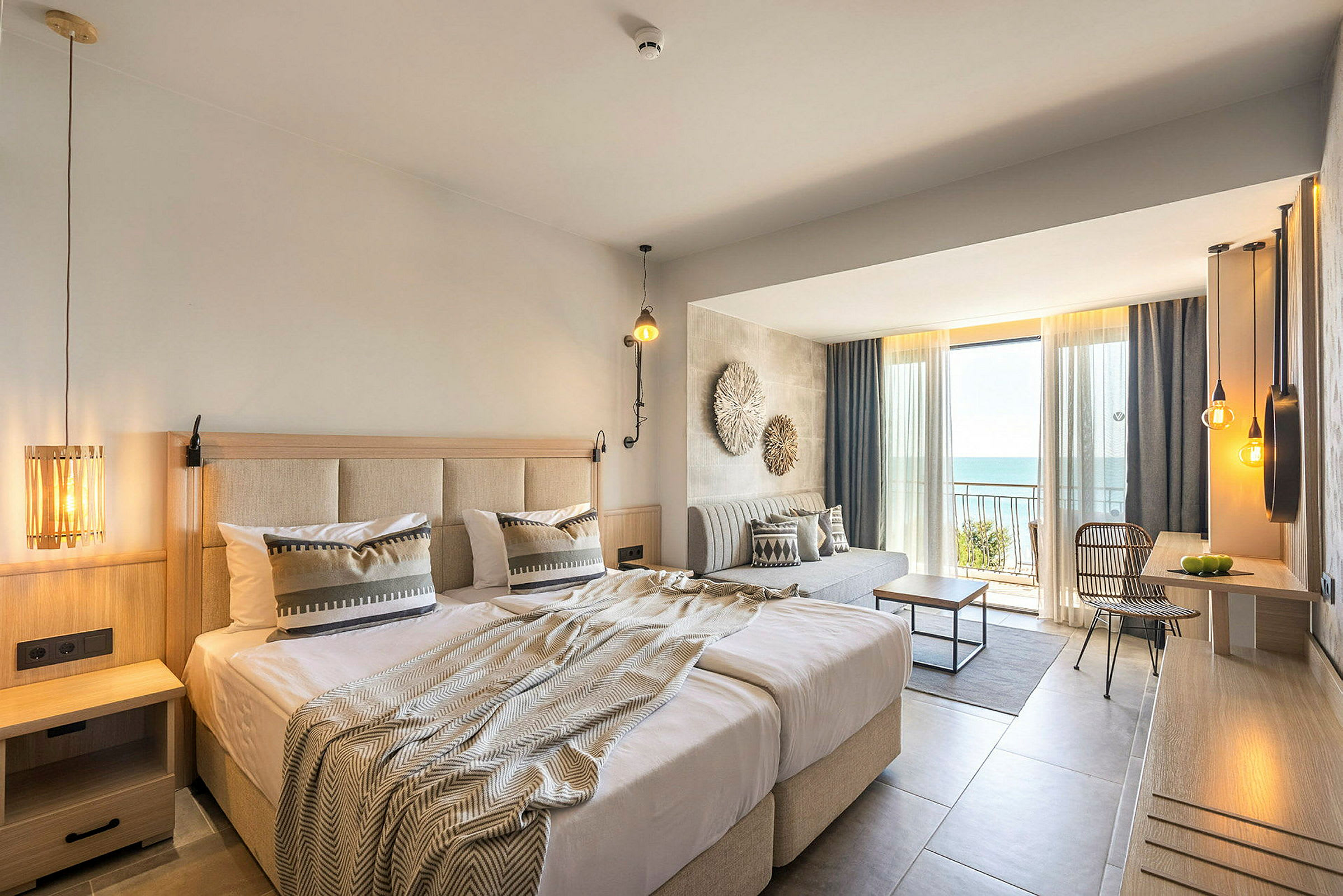 Hotelværelse med dobbeltseng, siddeområde og altan med udsigt over havet. (AI-genereret tekst)