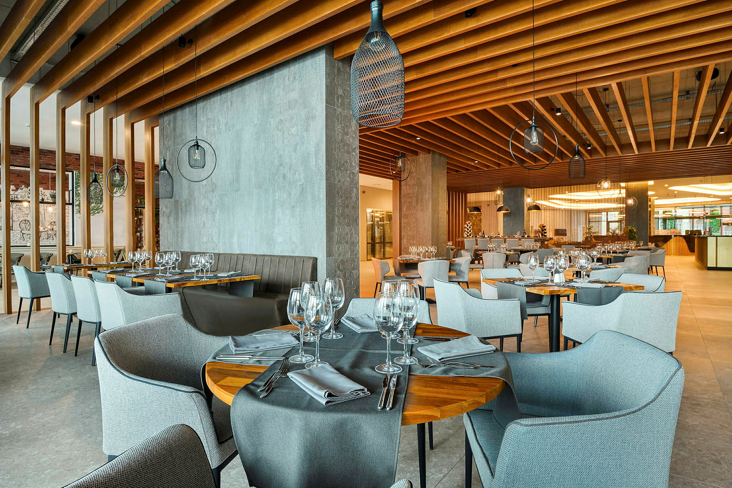 En elegant restaurant med borde og stole, dækket med glas og bestik. (AI-genereret tekst)