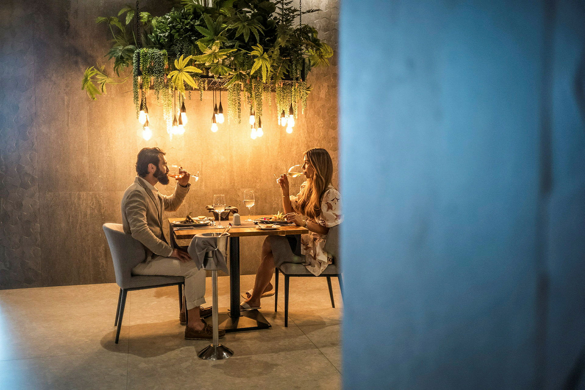 To personer sidder ved et dækket bord og spiser middag i en elegant atmosfære. (AI-genereret tekst)