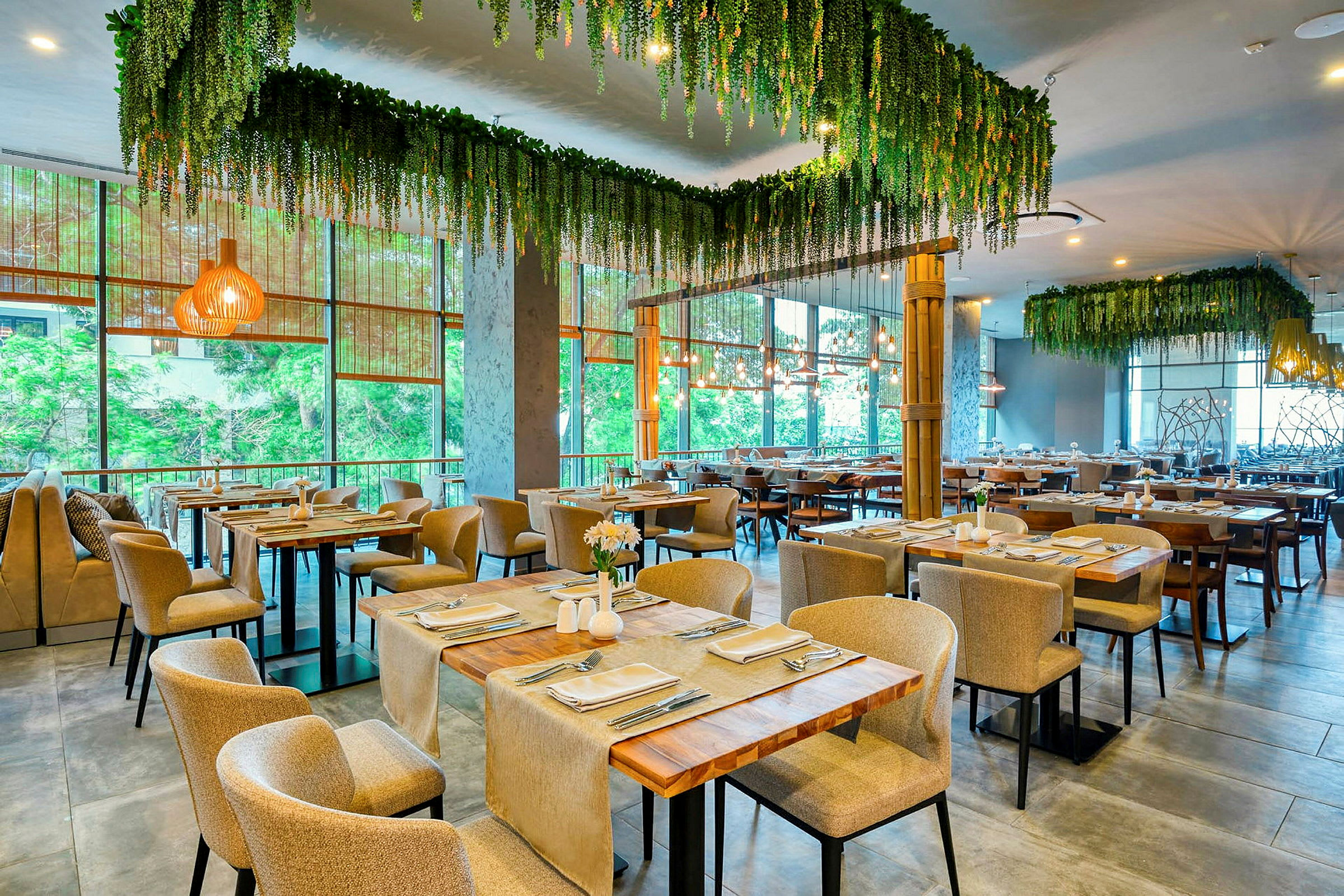 Restaurant med opdækkede borde og hængende grønt. (AI-genereret tekst)