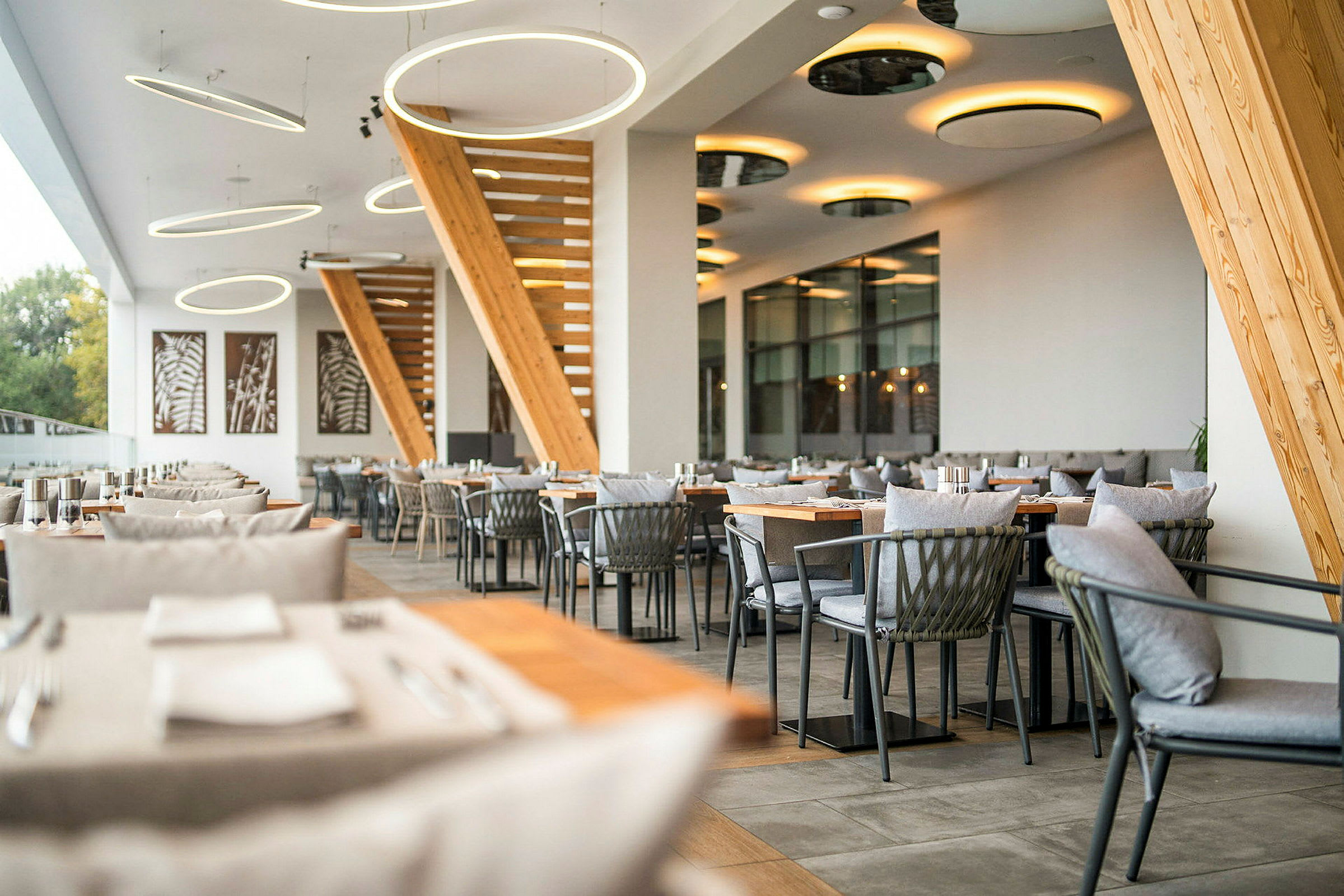 Billede af en moderne restaurant med stilfuld indretning, trædetaljer og hængende lys. (AI-genereret tekst)