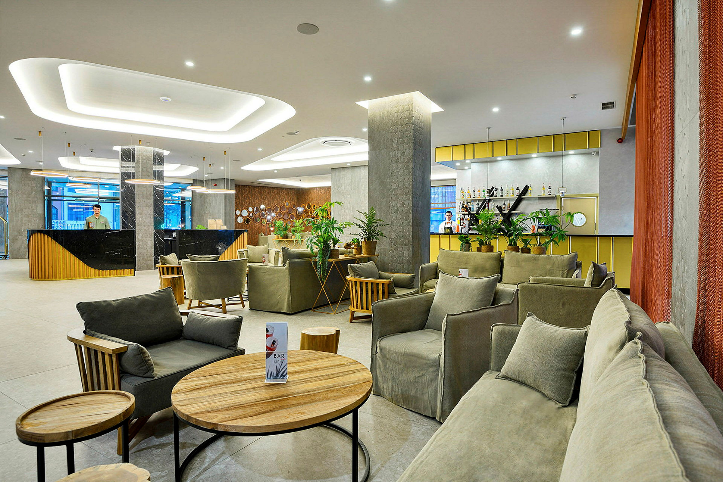 Et hotelområde med lounge og reception og bar, lyst og indbydende. (AI-genereret tekst)
