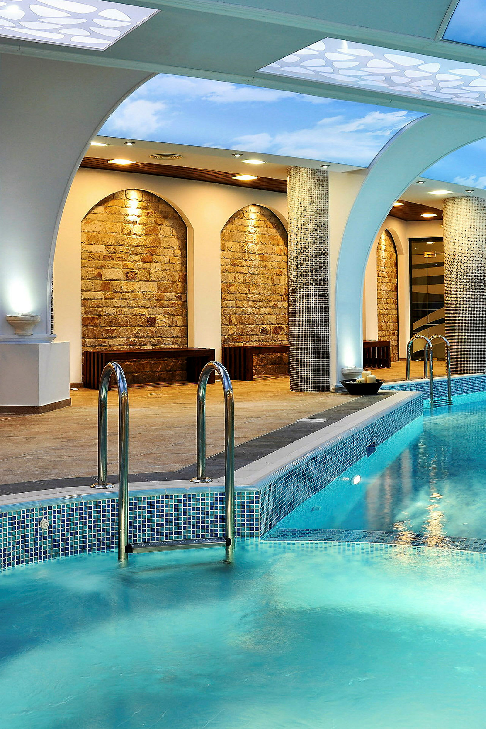 Indendørs swimmingpool med klart blåt vand og dekorativt buet loft. (AI-genereret tekst)