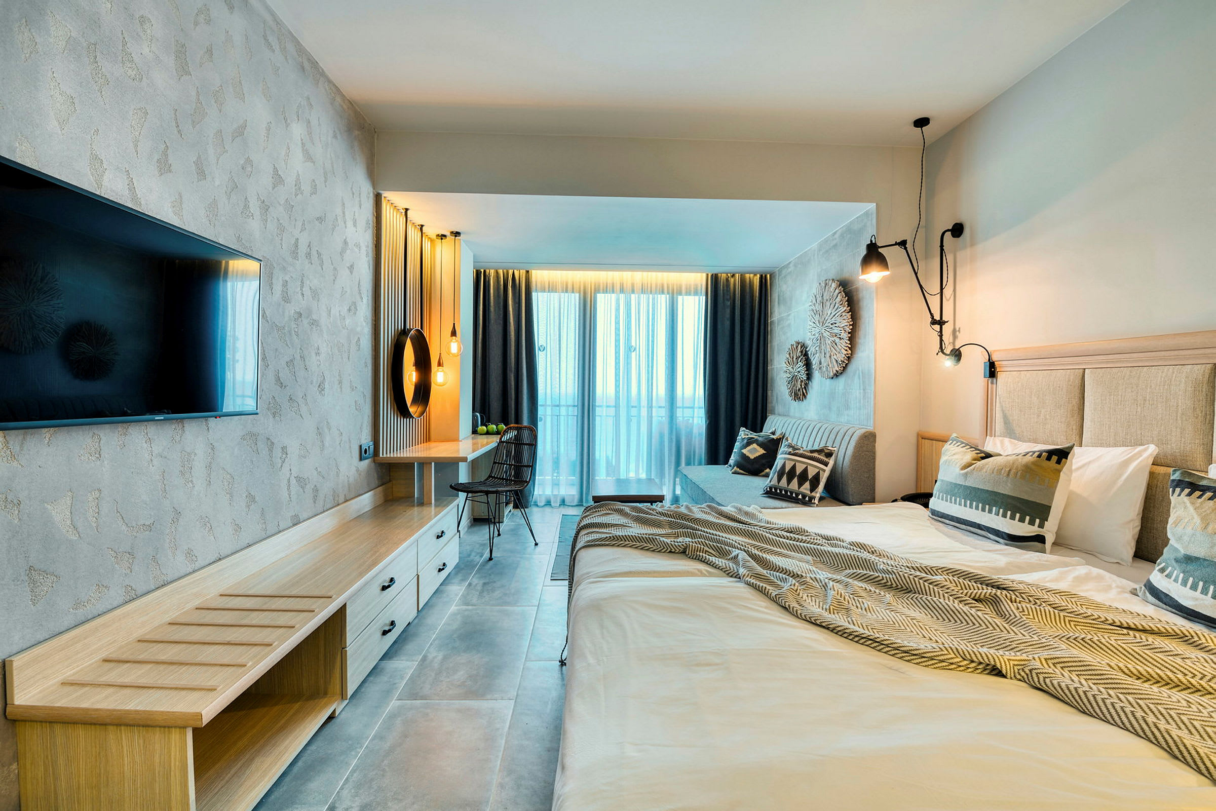 Moderne hotelværelse med dobbeltseng, TV, skrivebord og balkon. (AI-genereret tekst)