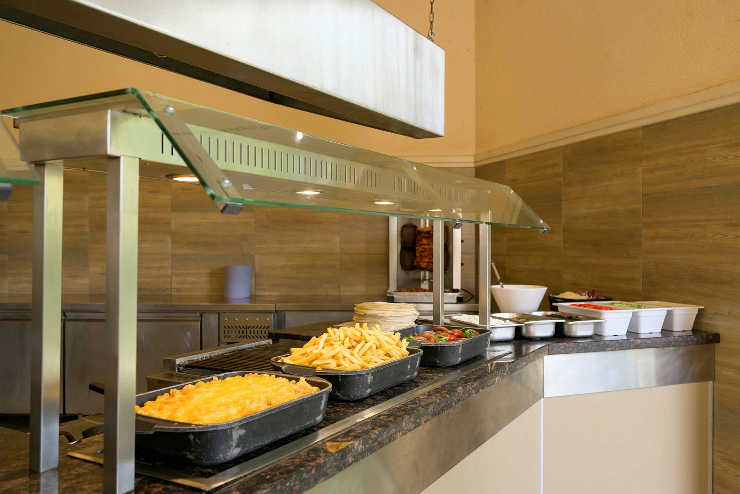Buffetområde med forskellige retter såsom pommes frites, gratin og salat. (AI-genereret tekst)