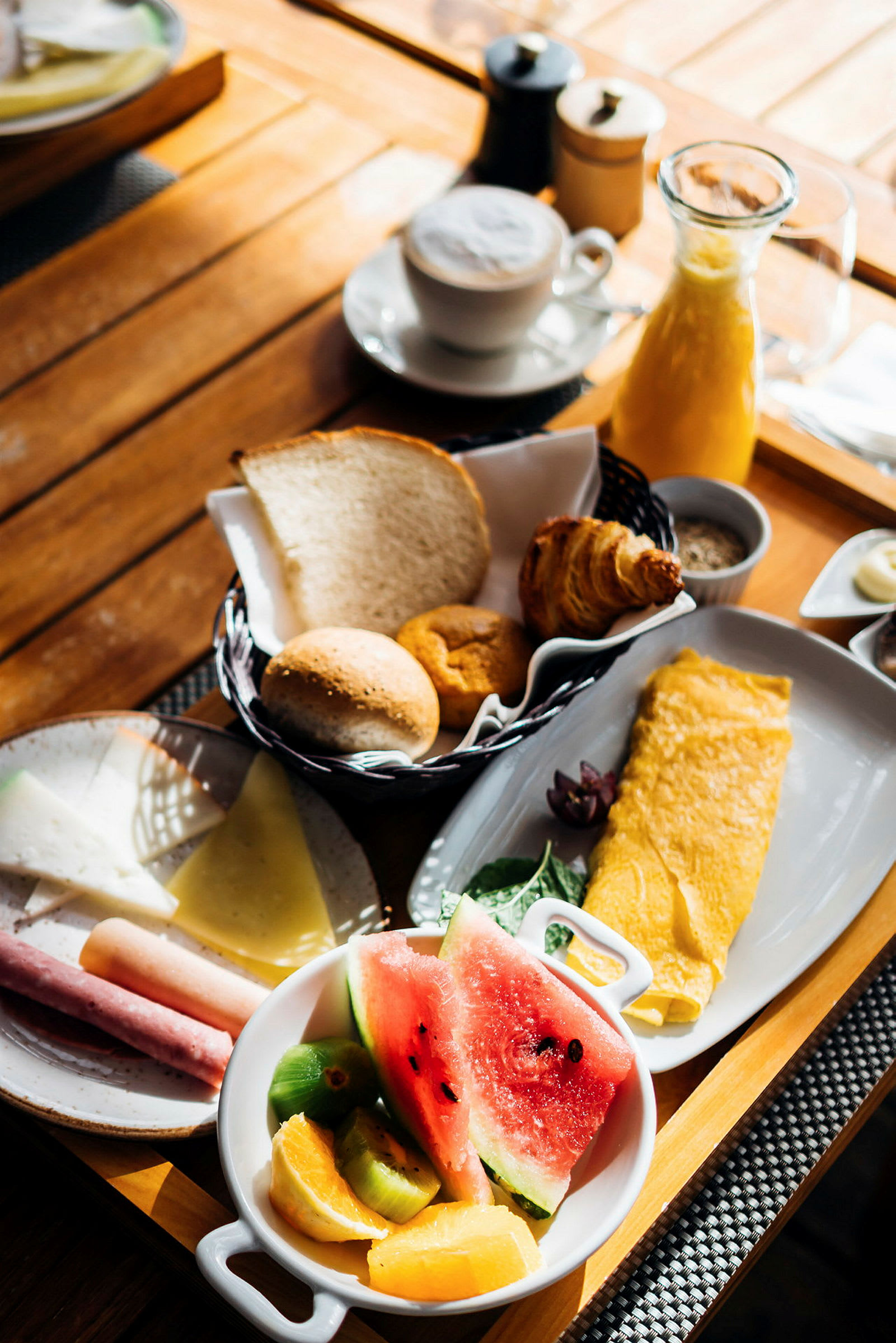 En morgenmadstallerken med omelet, frugt, brød og kaffe. (AI-genereret tekst)