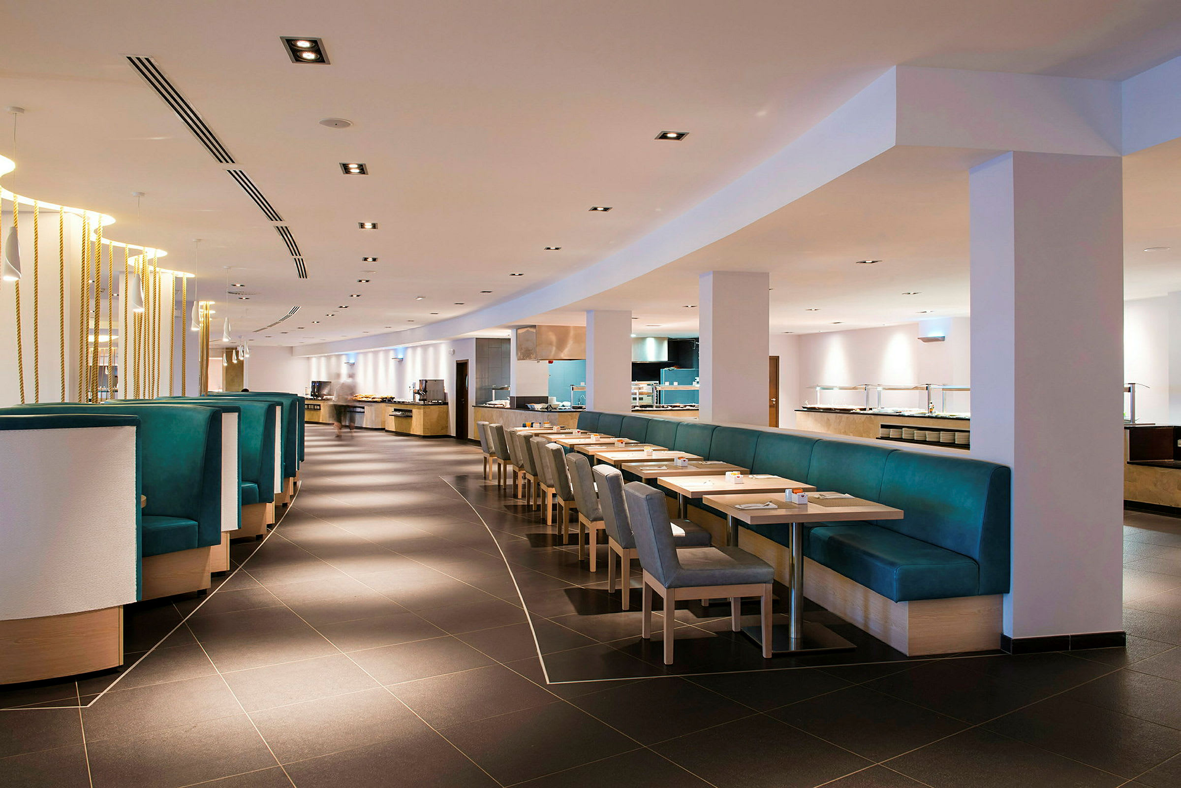 Billede af et moderne restaurantmiljø med borde, stole og bænke. (AI-genereret tekst)