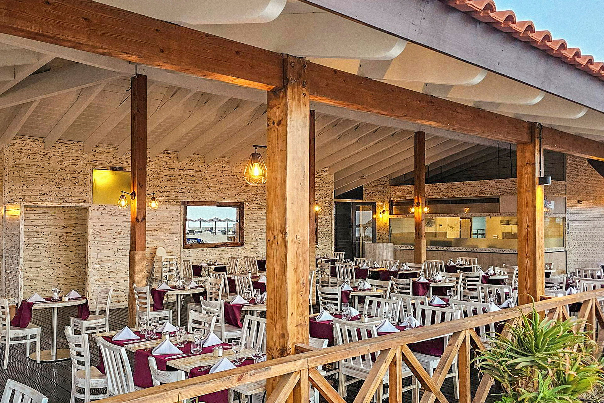 En restaurant med dækkede borde og træstolper. (AI-genereret tekst)