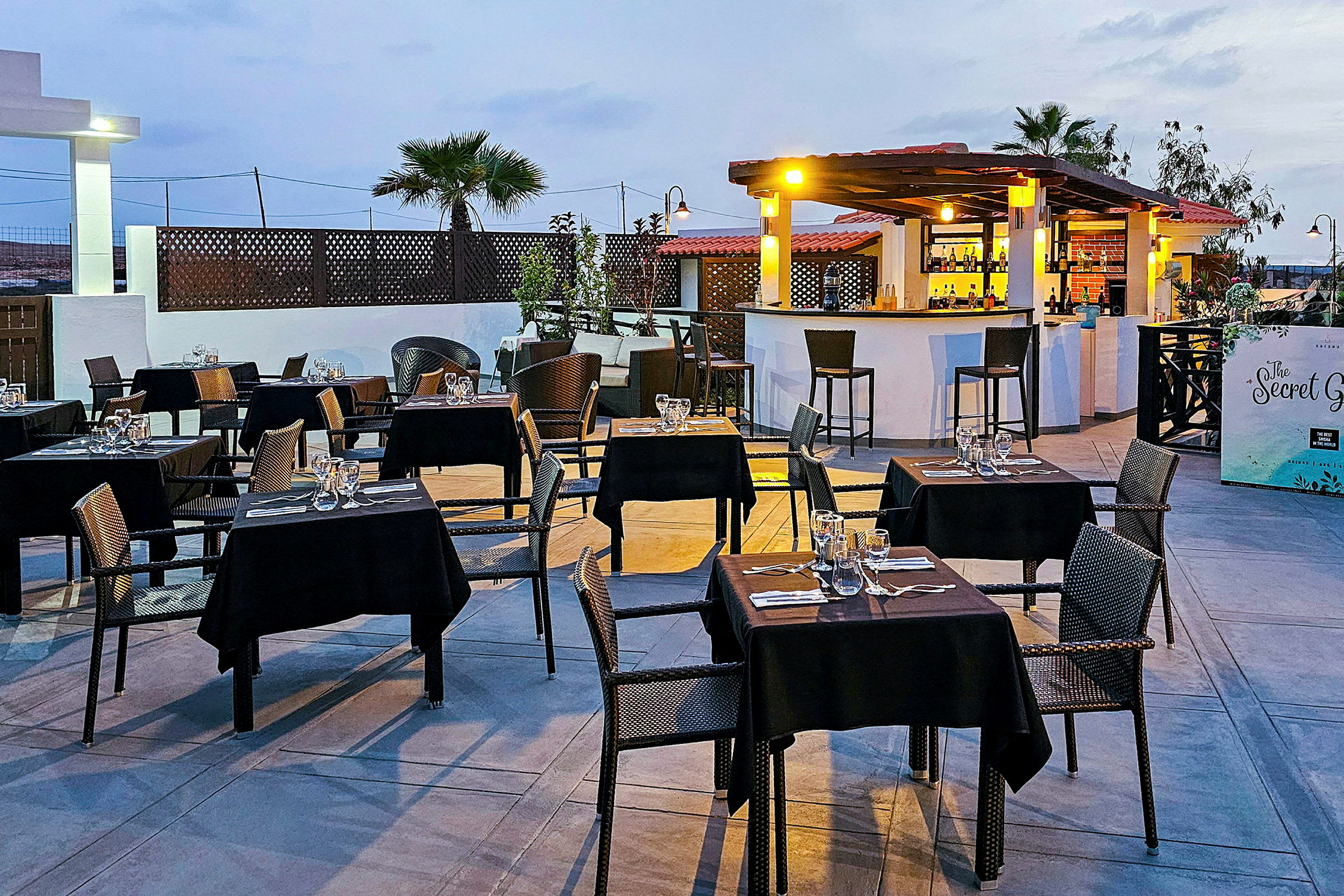 Udendørsrestaurant med dækkede borde og en bar. (AI-genereret tekst)