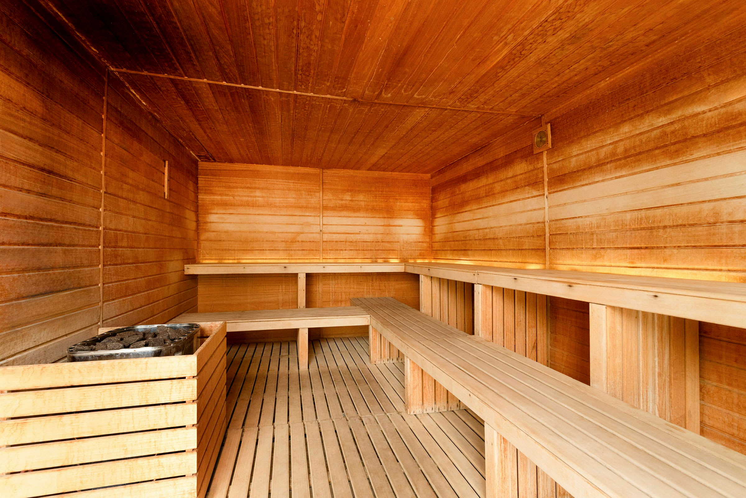 Indendørs sauna med træpaneler og bænke. (AI-genereret tekst)