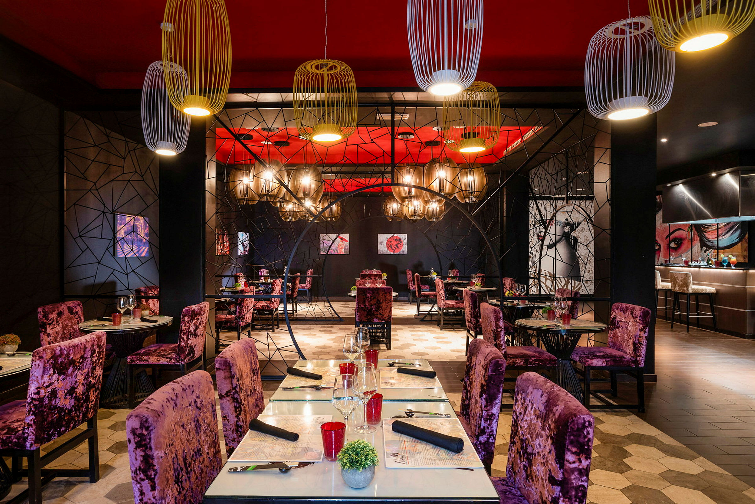 En restaurant med dekorative stole og borde, en farverig indretning og hængende lamper. (AI-genereret tekst)