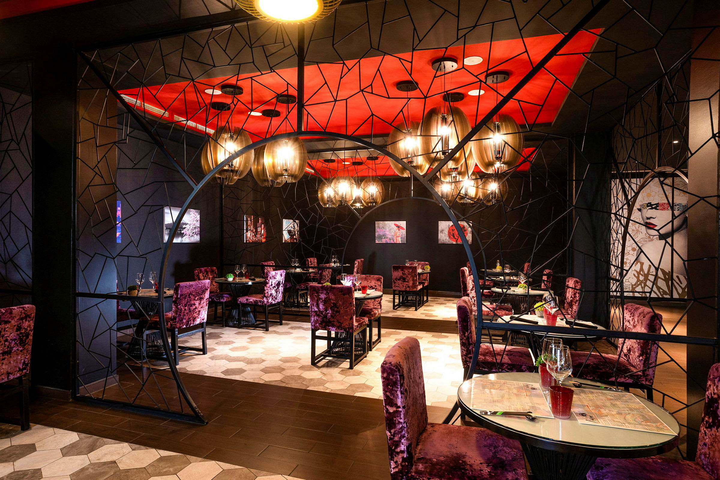 En elegant restaurantindretning med dekorative elementer, røde lofter og lilla stole. (AI-genereret tekst)