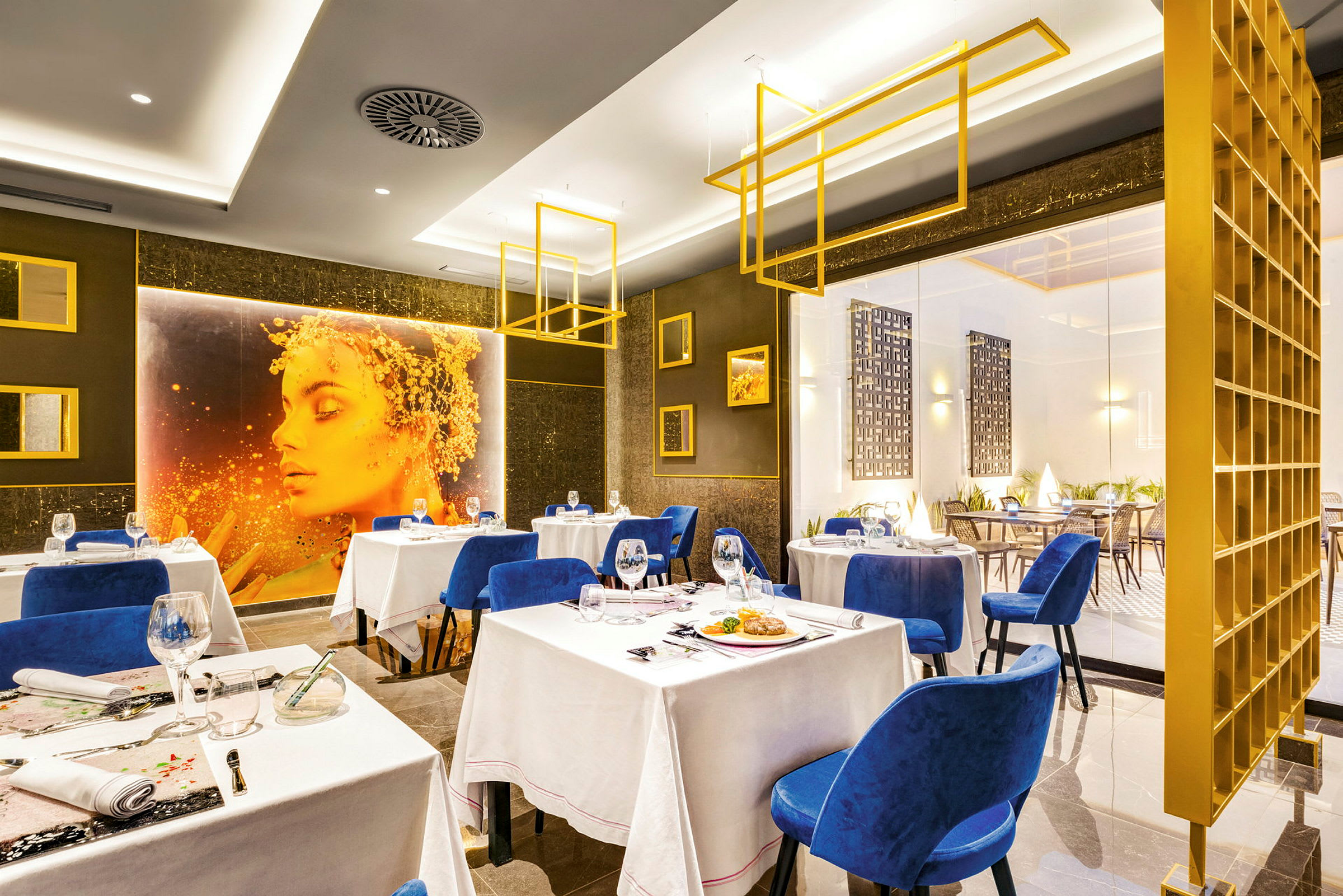 En elegant restaurant med blå stole, hvide duge og moderne indretning. (AI-genereret tekst)