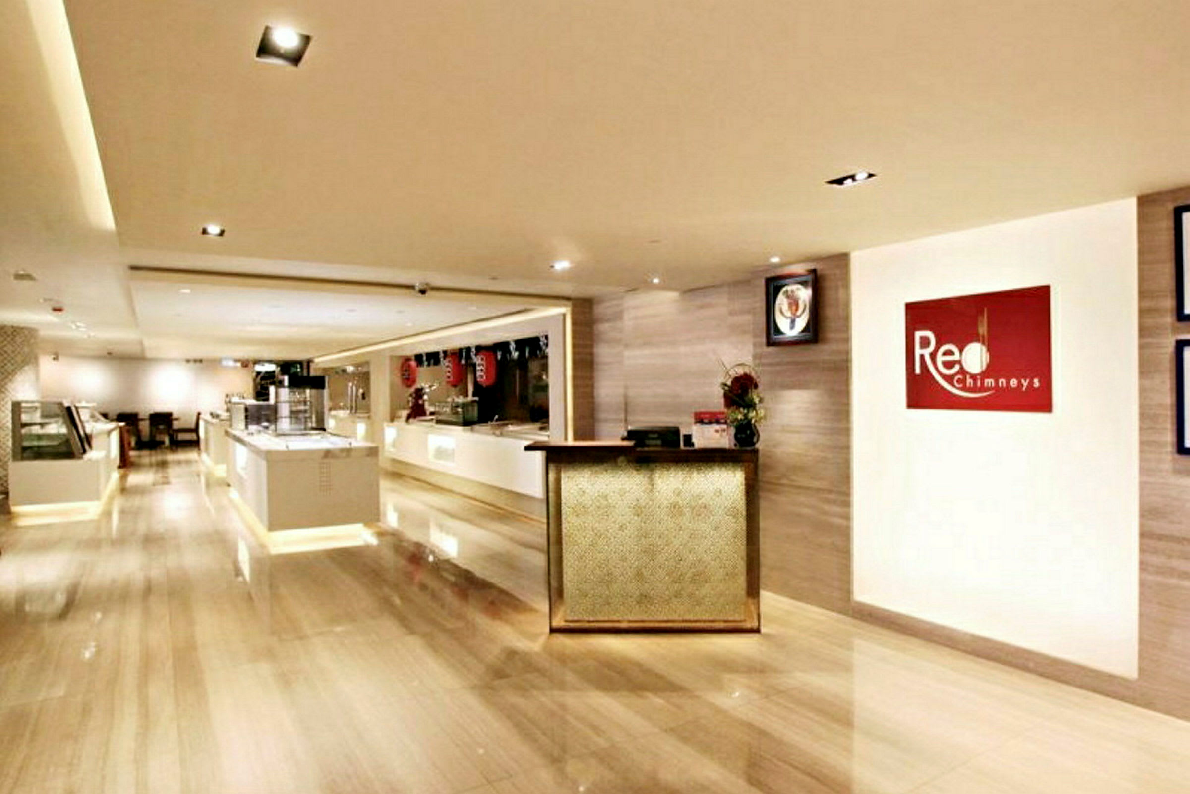 Reception og spiseområde med lys indretning og et skilt med teksten "Red Chimneys". (AI-genereret tekst)