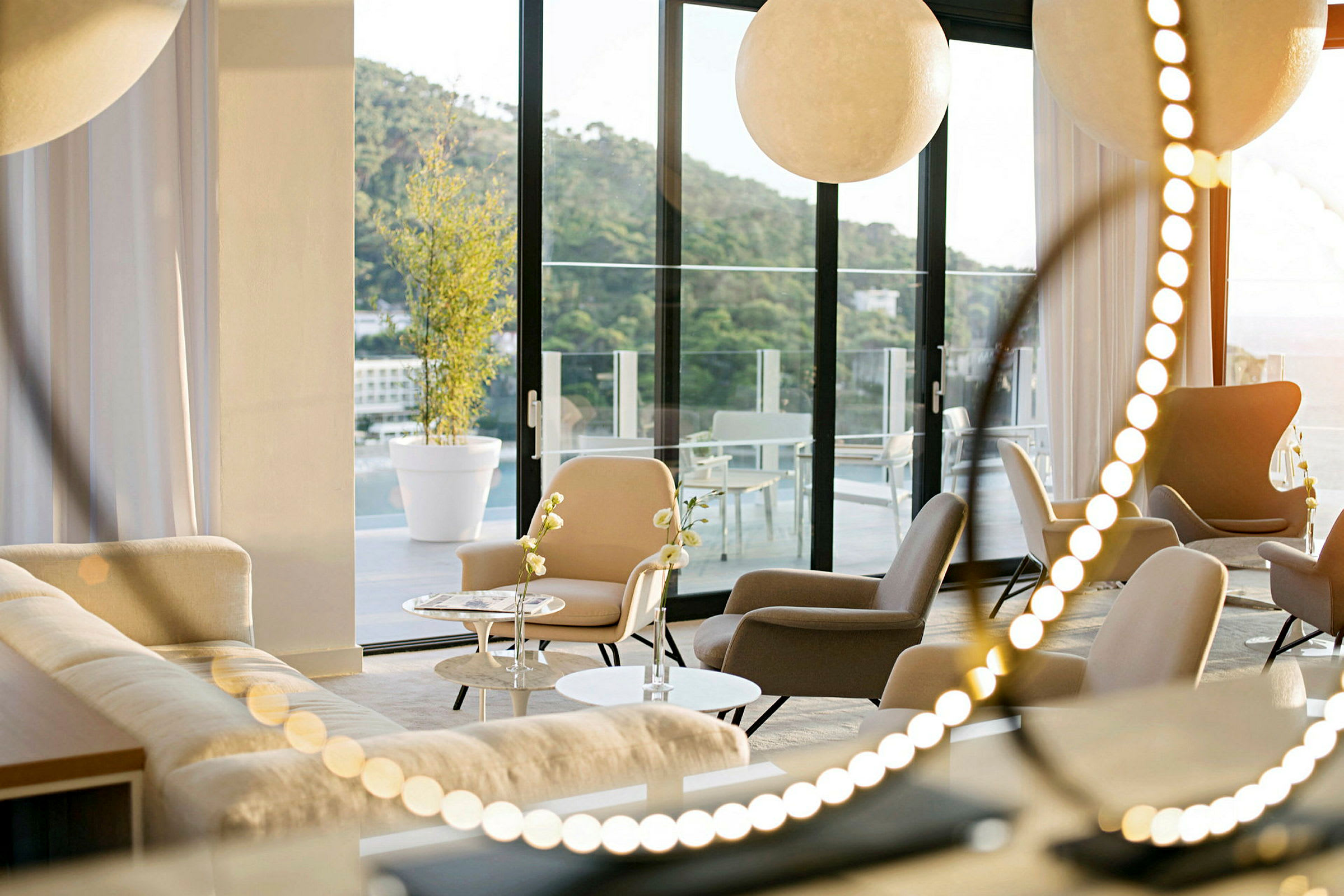Et moderne rum med siddepladser og sofaer, store vinduer der vender ud mod en terrasse. (AI-genereret tekst)