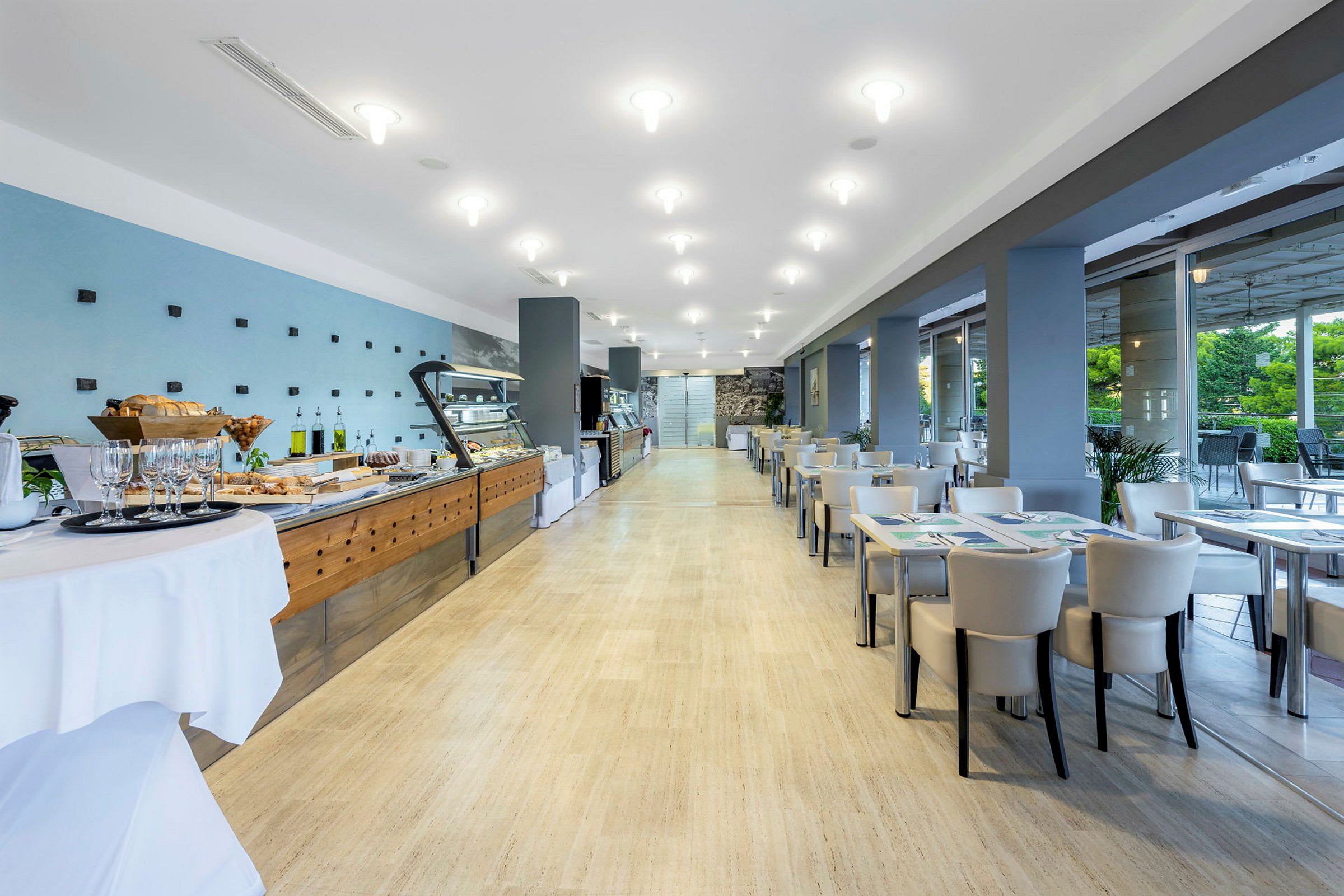 En lys og moderne restaurant med buffet til venstre og siddepladser til højre. (AI-genereret tekst)
