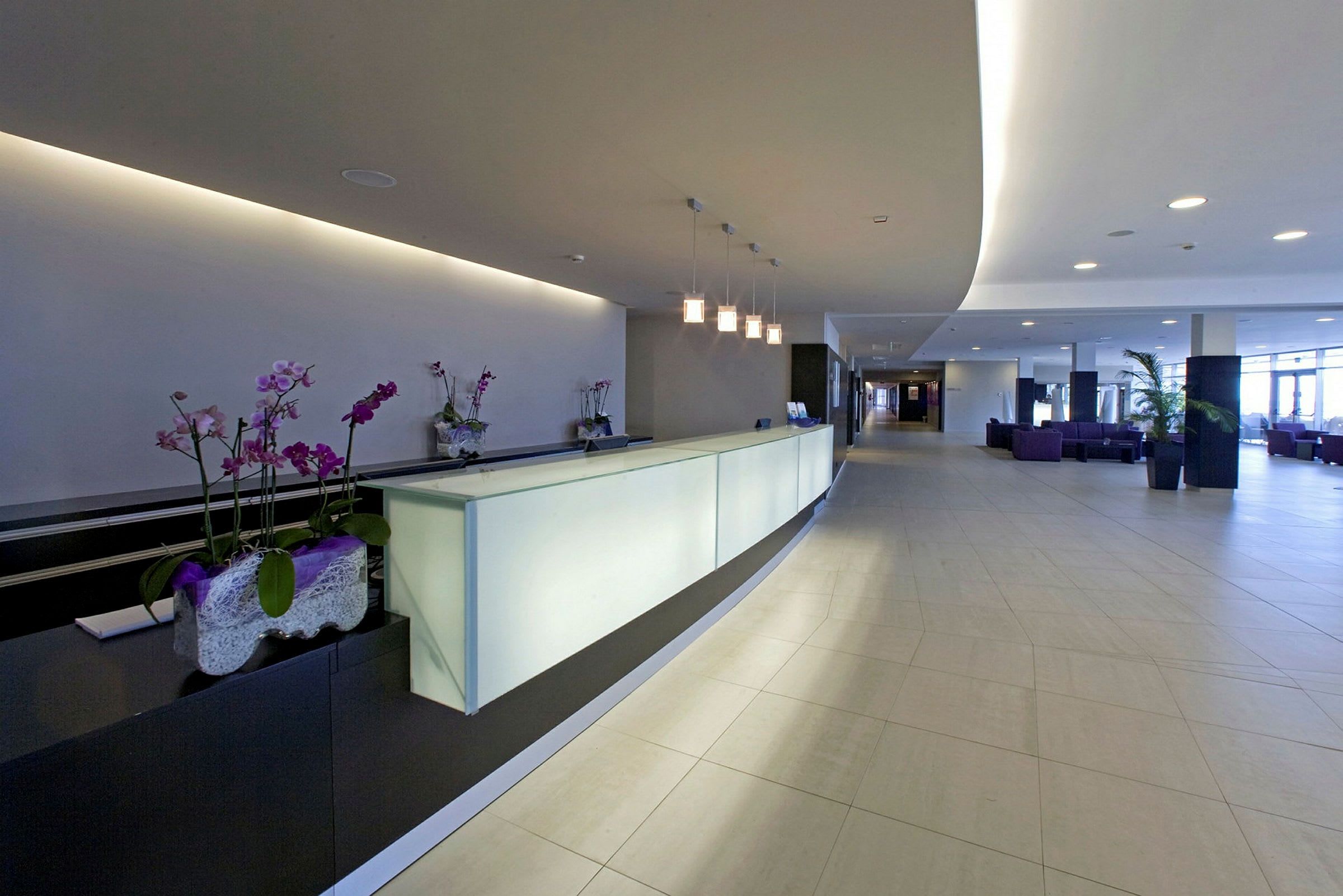 Det lyse receptionsområde på et hotel med moderne design og belysning. (AI-genereret tekst)