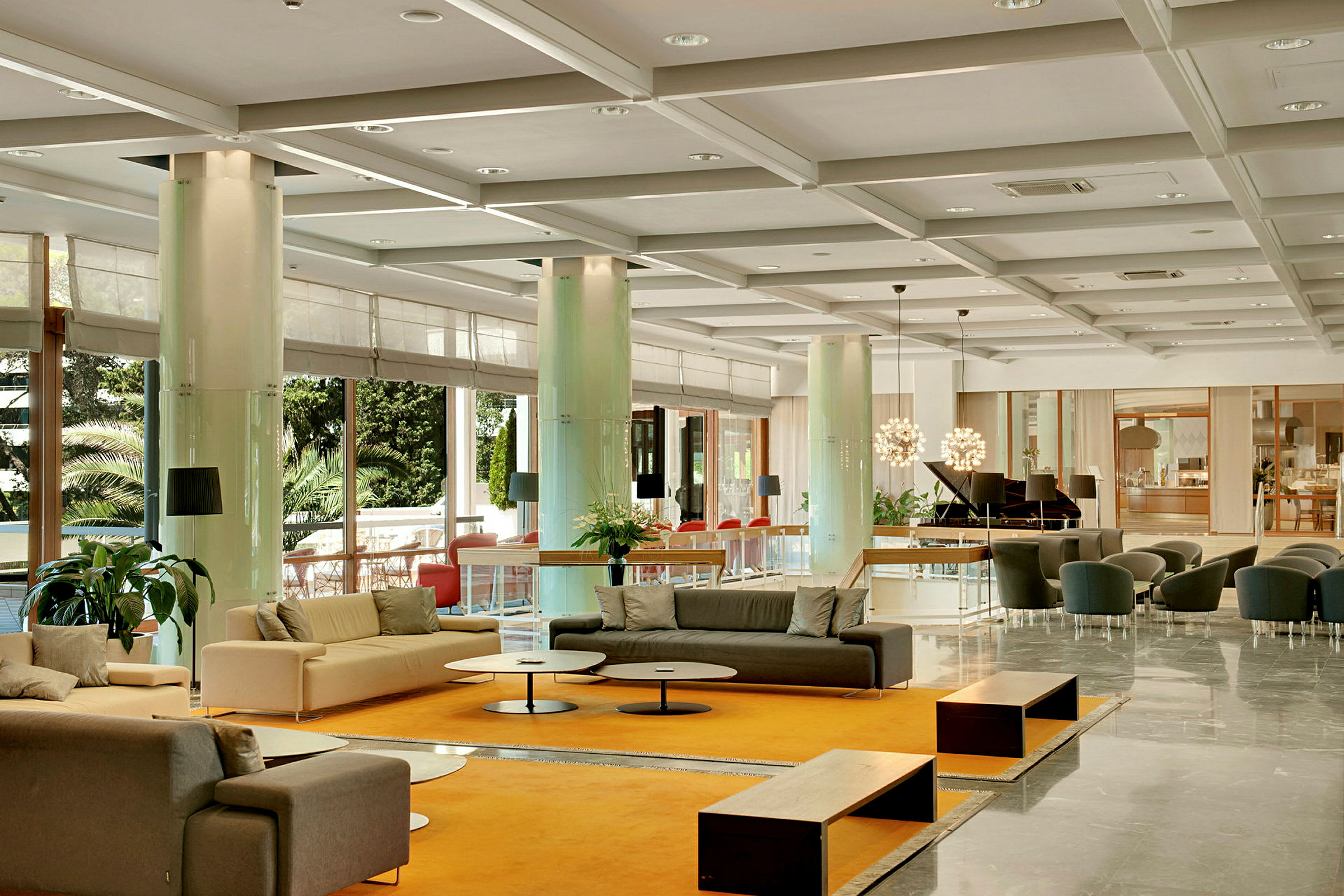En lys og rummelig hotellobby med sofaer, borde og dekorative planter. (AI-genereret tekst)