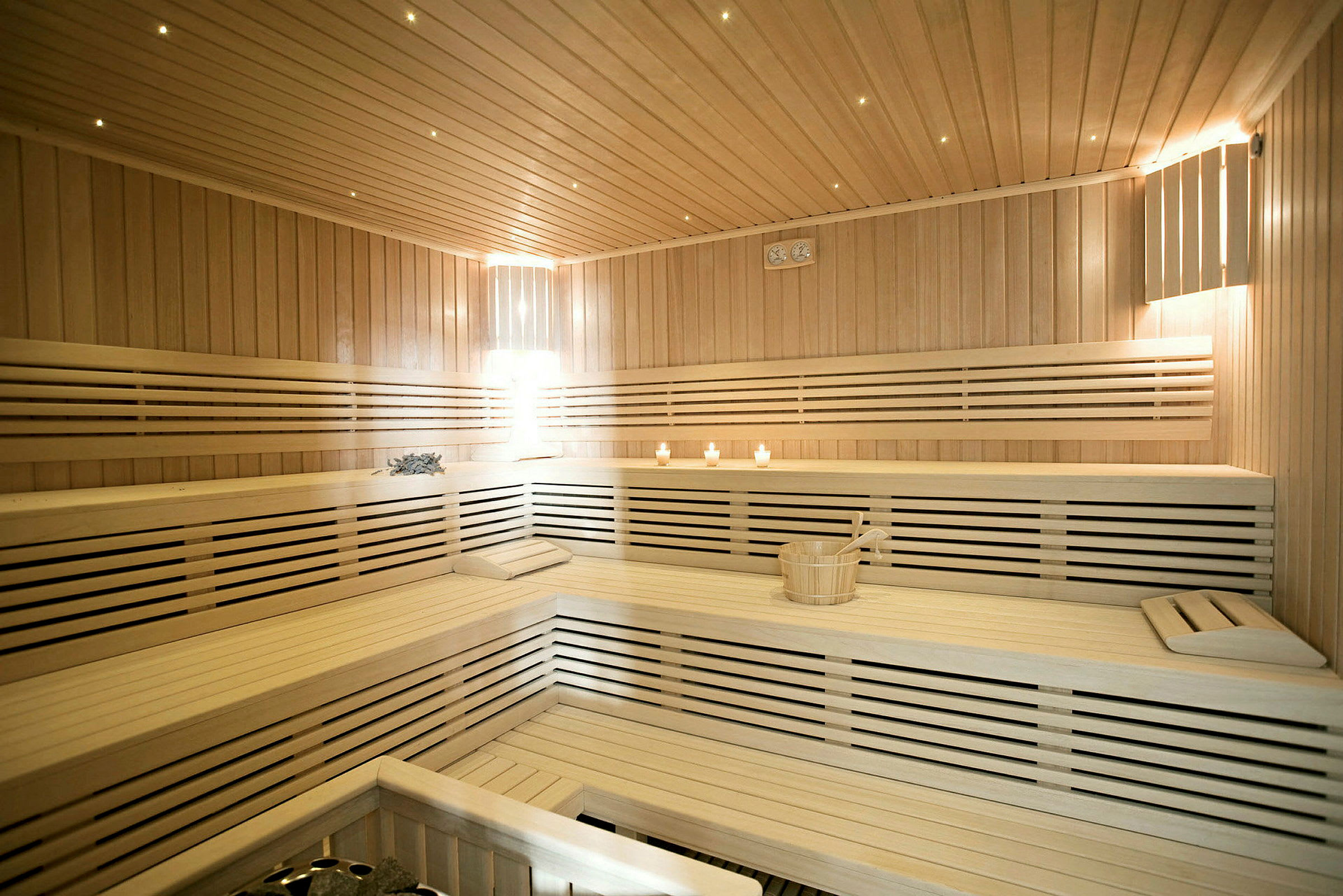 En sauna med træbænke og tændte lys. (AI-genereret tekst)