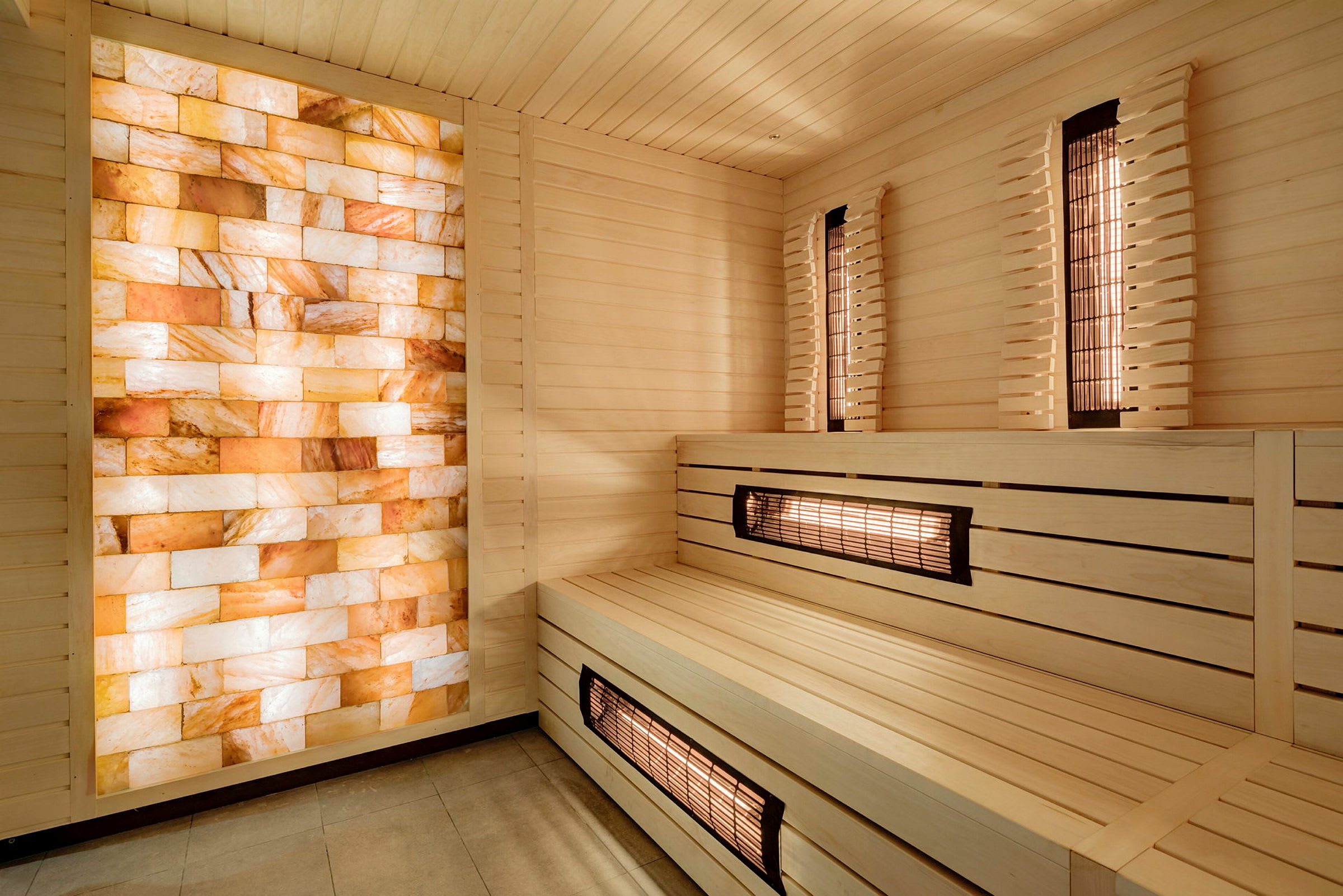 Sauna med træpaneler og en væg af orange og hvide saltkrystaller. (AI-genereret tekst)