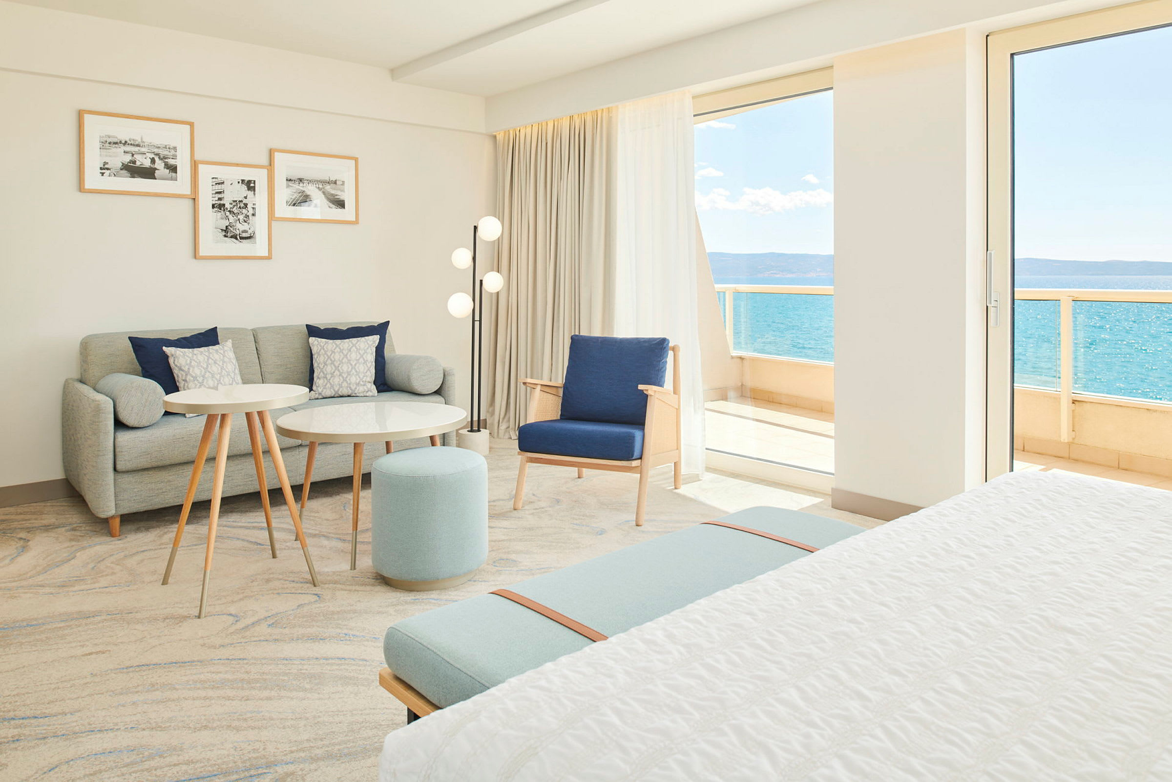 Lyst og moderne hotelværelse med siddeområde og udsigt til havet. (AI-genereret tekst)