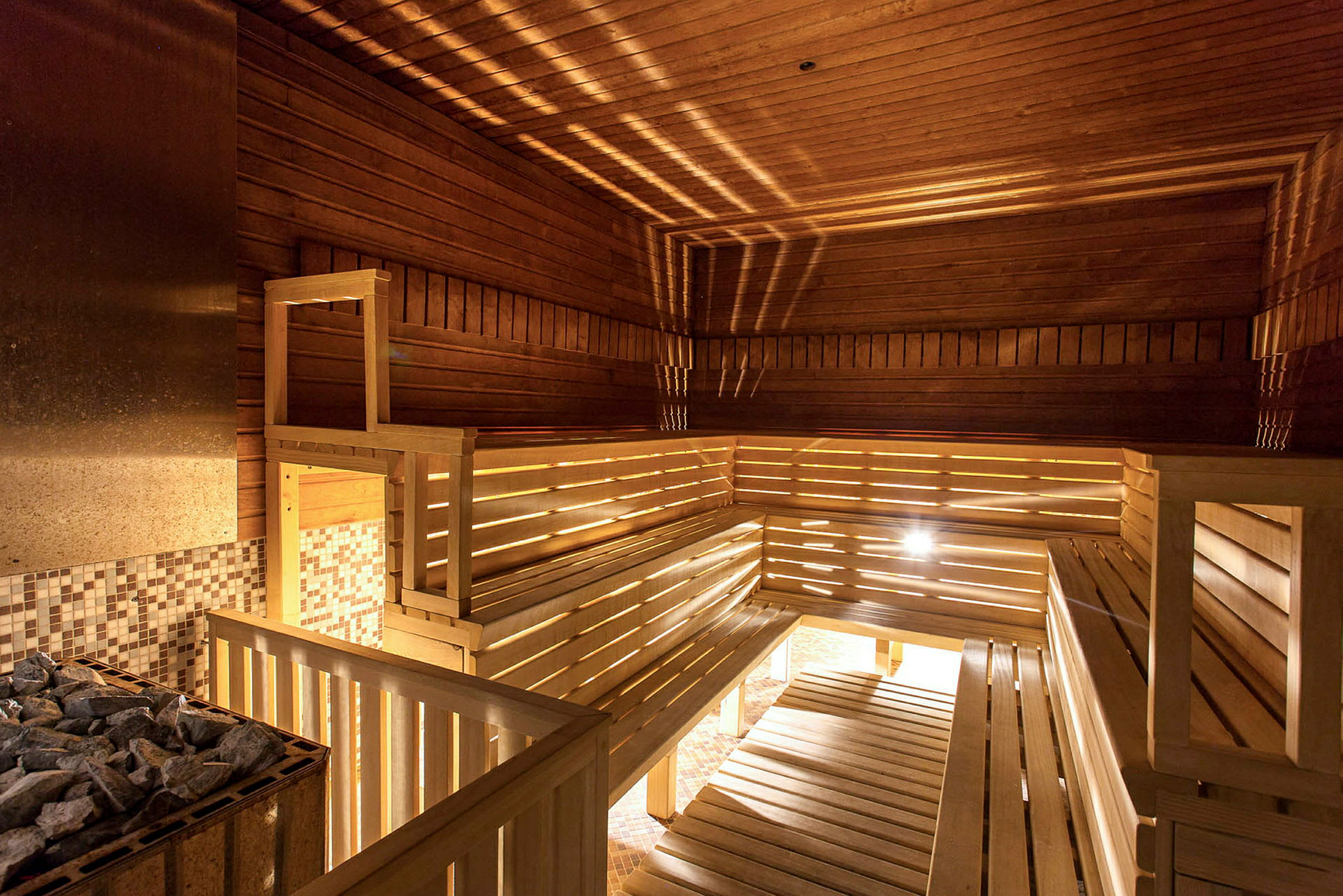 Interiøret i en sauna med træpaneler og bænke. (AI-genereret tekst)