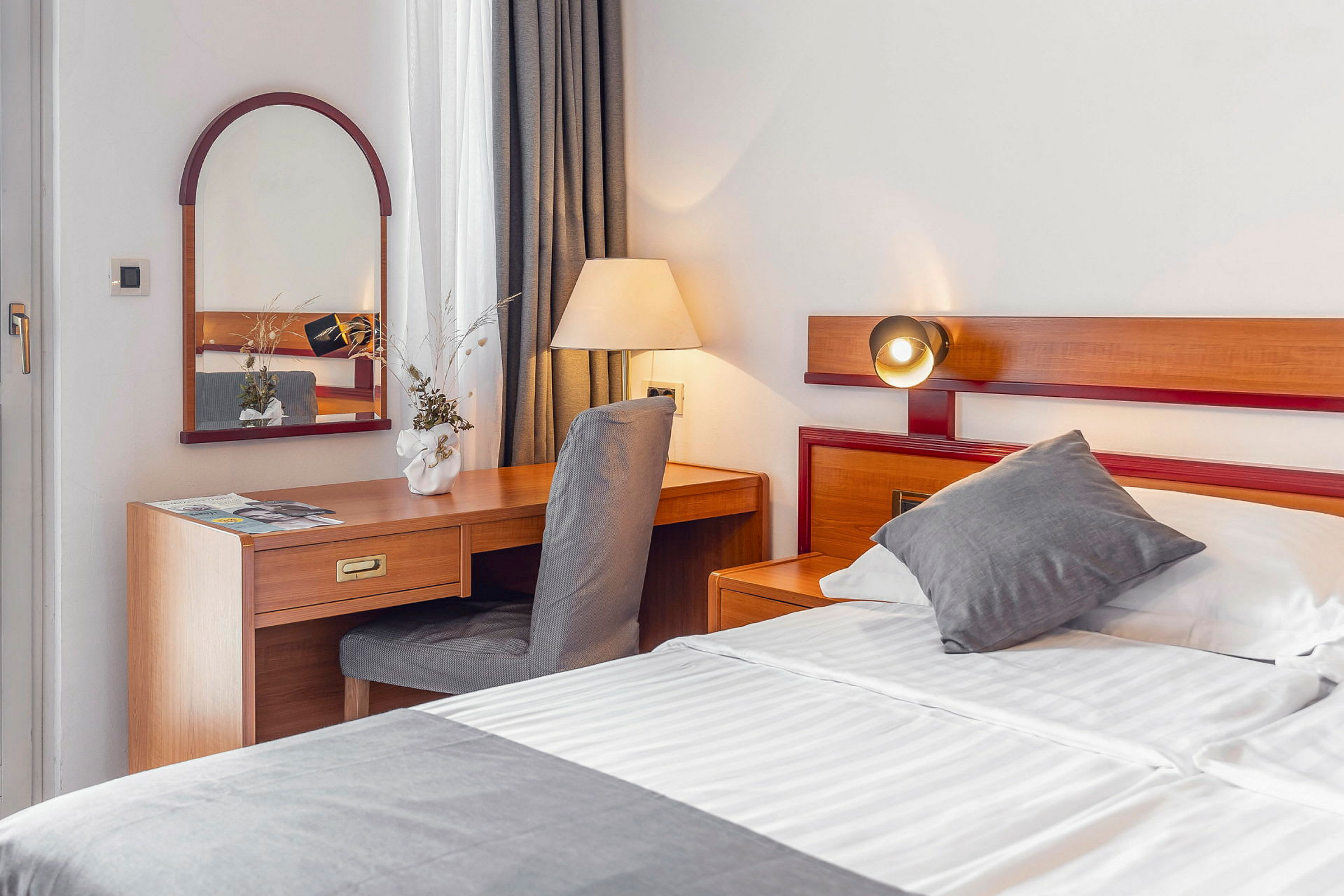 Hotelværelse med seng og skrivebord. (AI-genereret tekst)