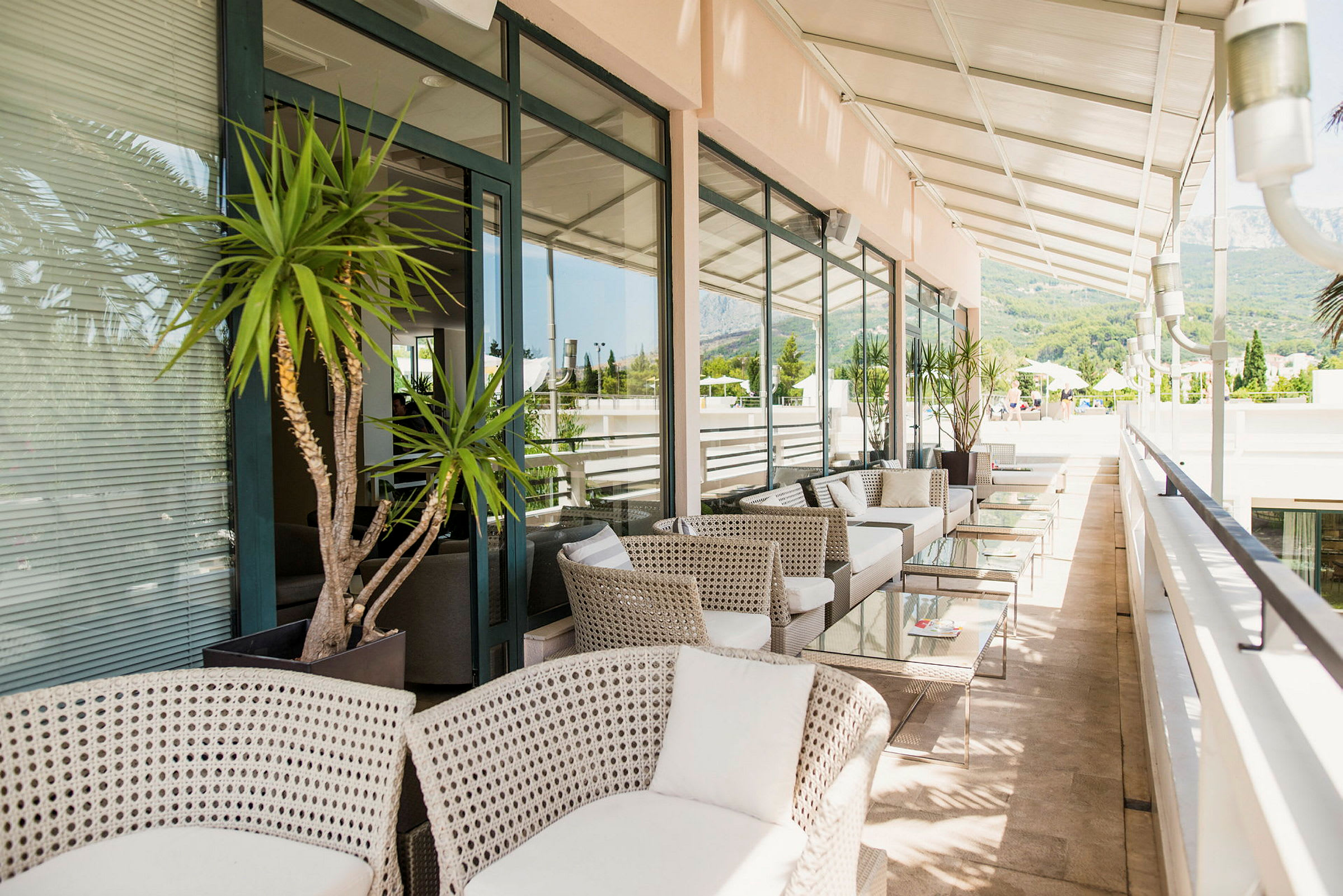 Terrasse med moderne møbler og glasborde under et pergolatag. (AI-genereret tekst)