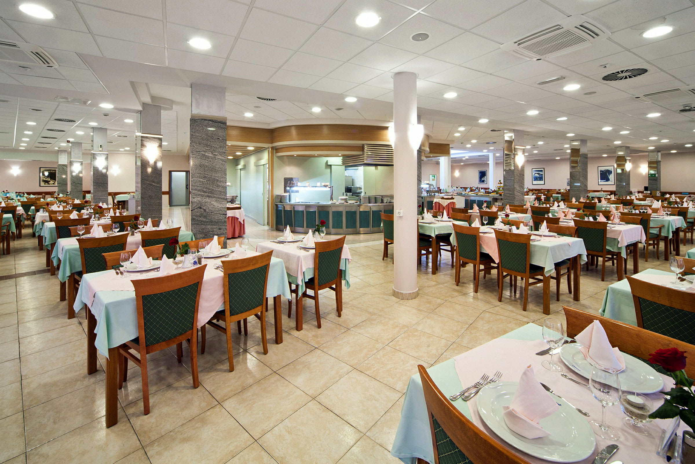 En restaurant med dækkede borde og stole, tom og oplyst. (AI-genereret tekst)