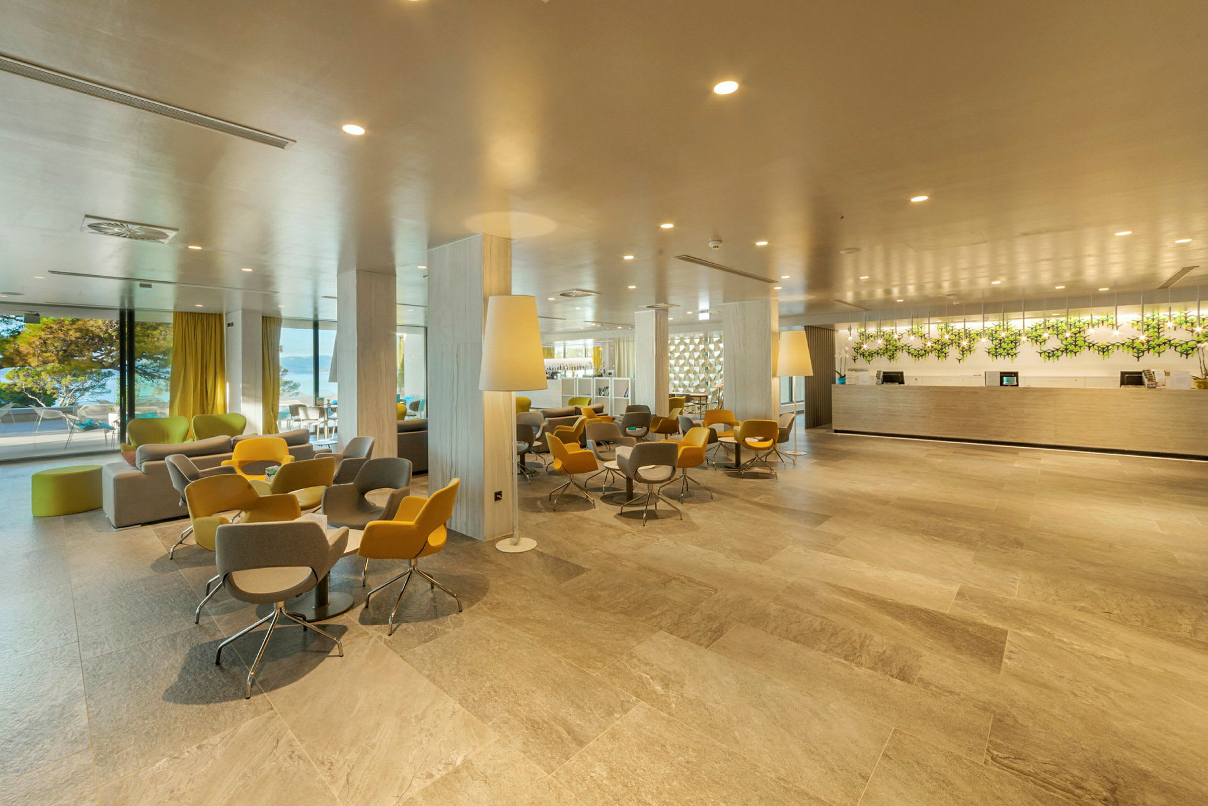 Hotellets lobby med reception og siddegrupper i moderne indretning. (AI-genereret tekst)