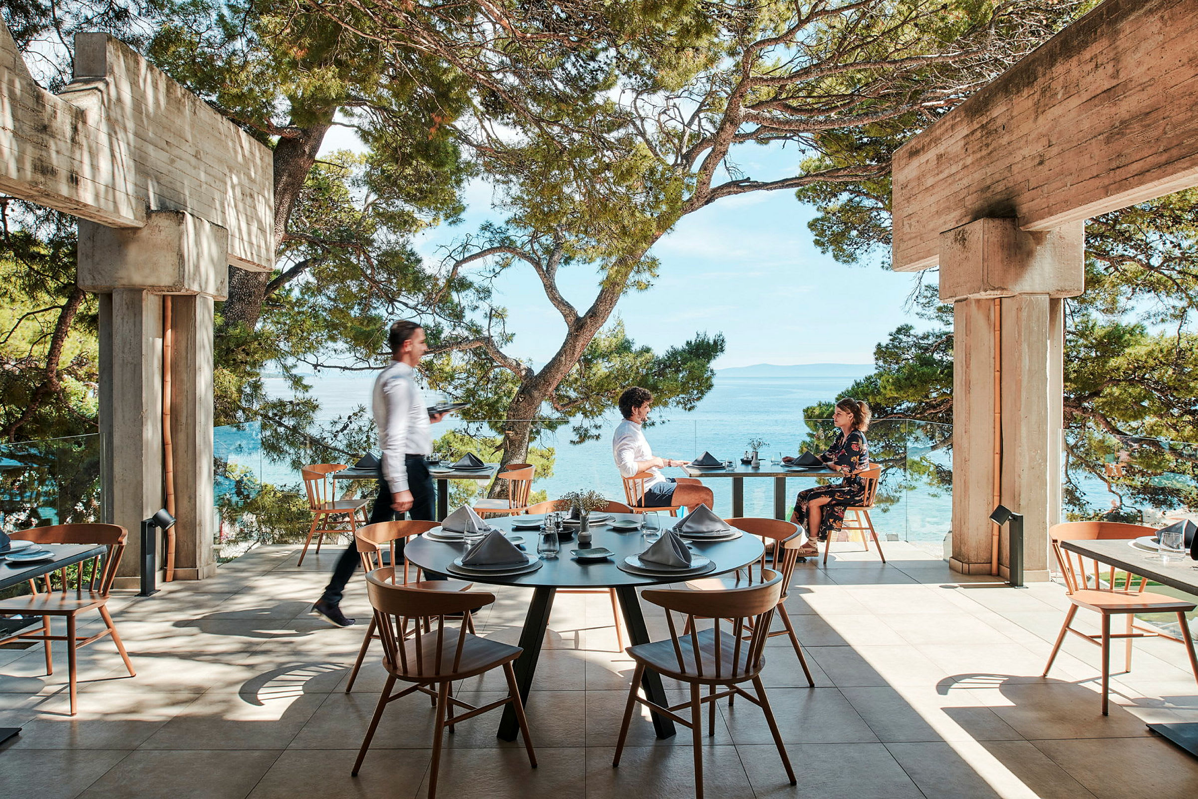 Restaurant på en terrasse med udsigt over havet. (AI-genereret tekst)