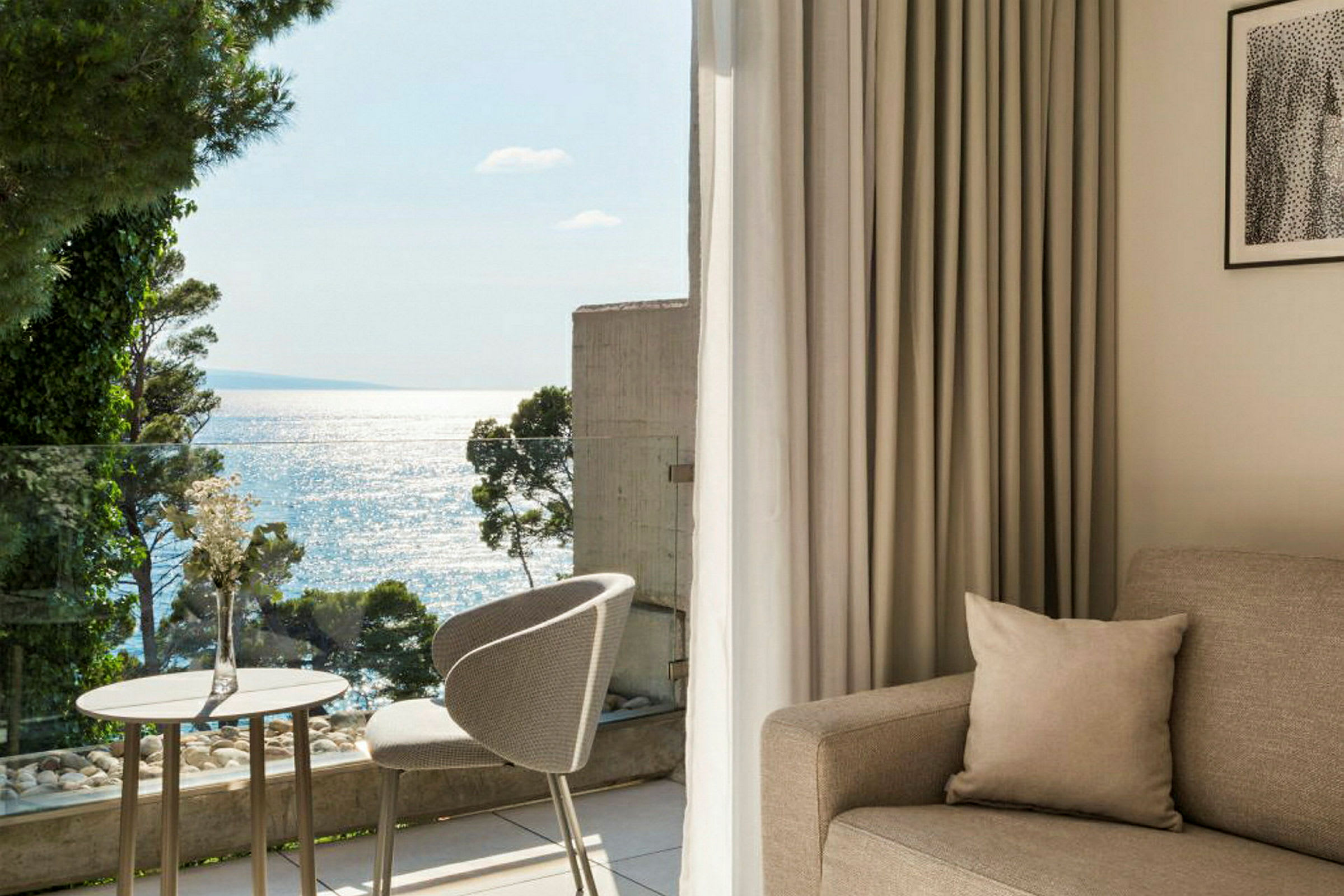 Lyst og moderne hotelværelse med havudsigt fra balkonen. (AI-genereret tekst)