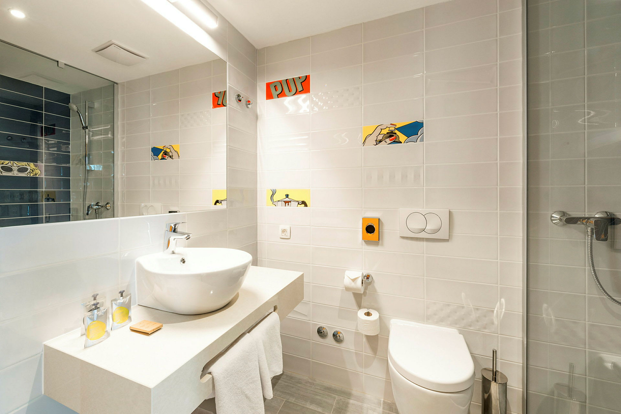 Et moderne badeværelse med vask, toilet og brusekabine. Væggene er hvide med dekorative mønstre. (AI-genereret tekst)