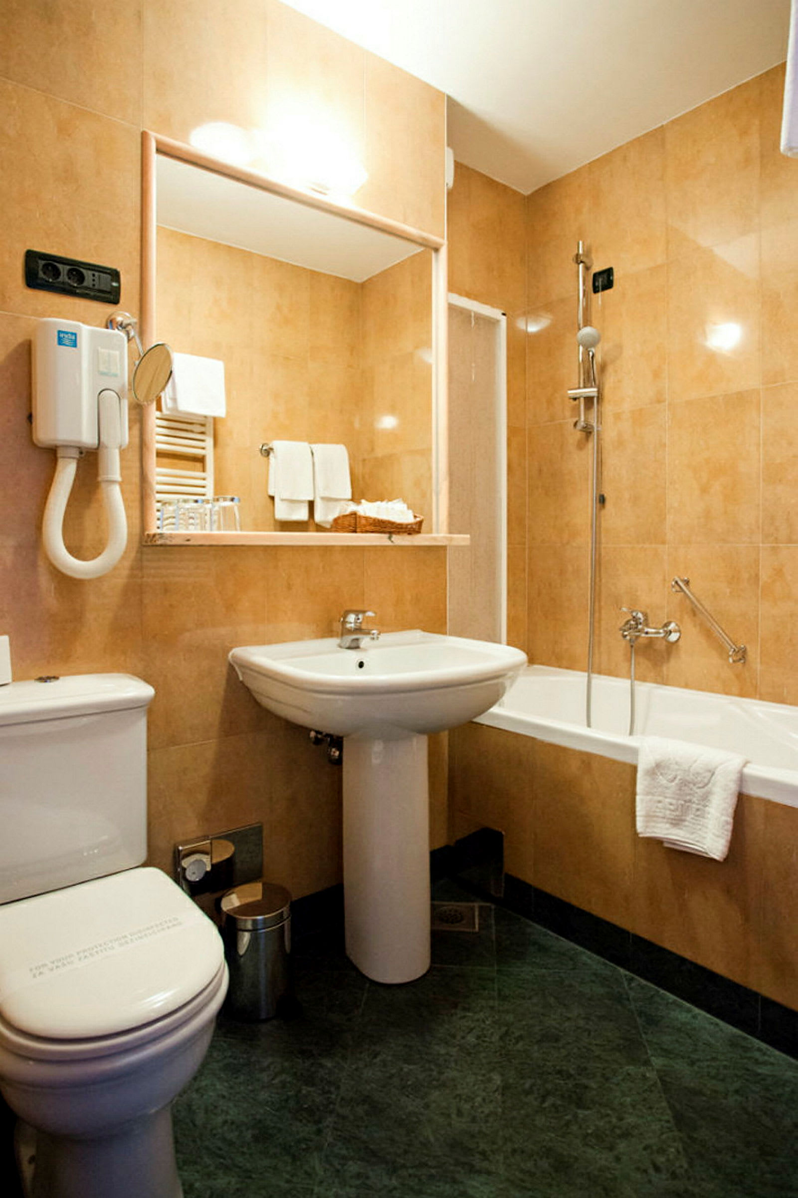 Et badeværelse med håndvask, toilet, badekar og bruser, alt indrettet i lyse toner. (AI-genereret tekst)