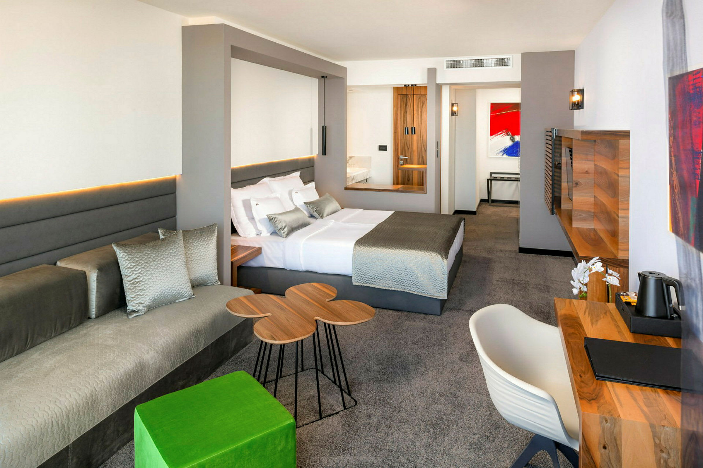 Moderne hotelværelse med en stor seng, skrivebord og siddeområde. (AI-genereret tekst)