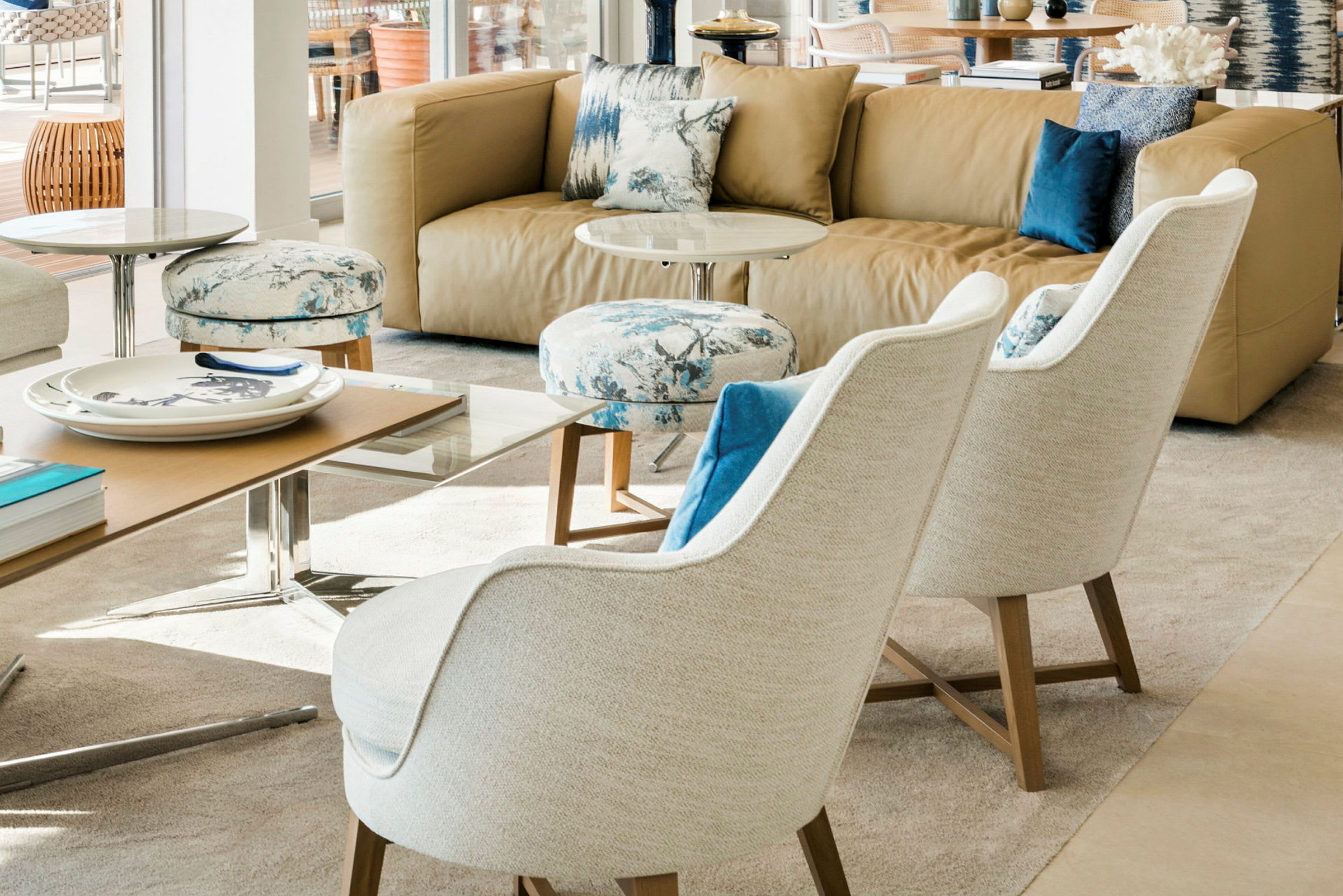 En moderne stue med en beige sofa, to hvide lænestole og et sofabord. (AI-genereret tekst)