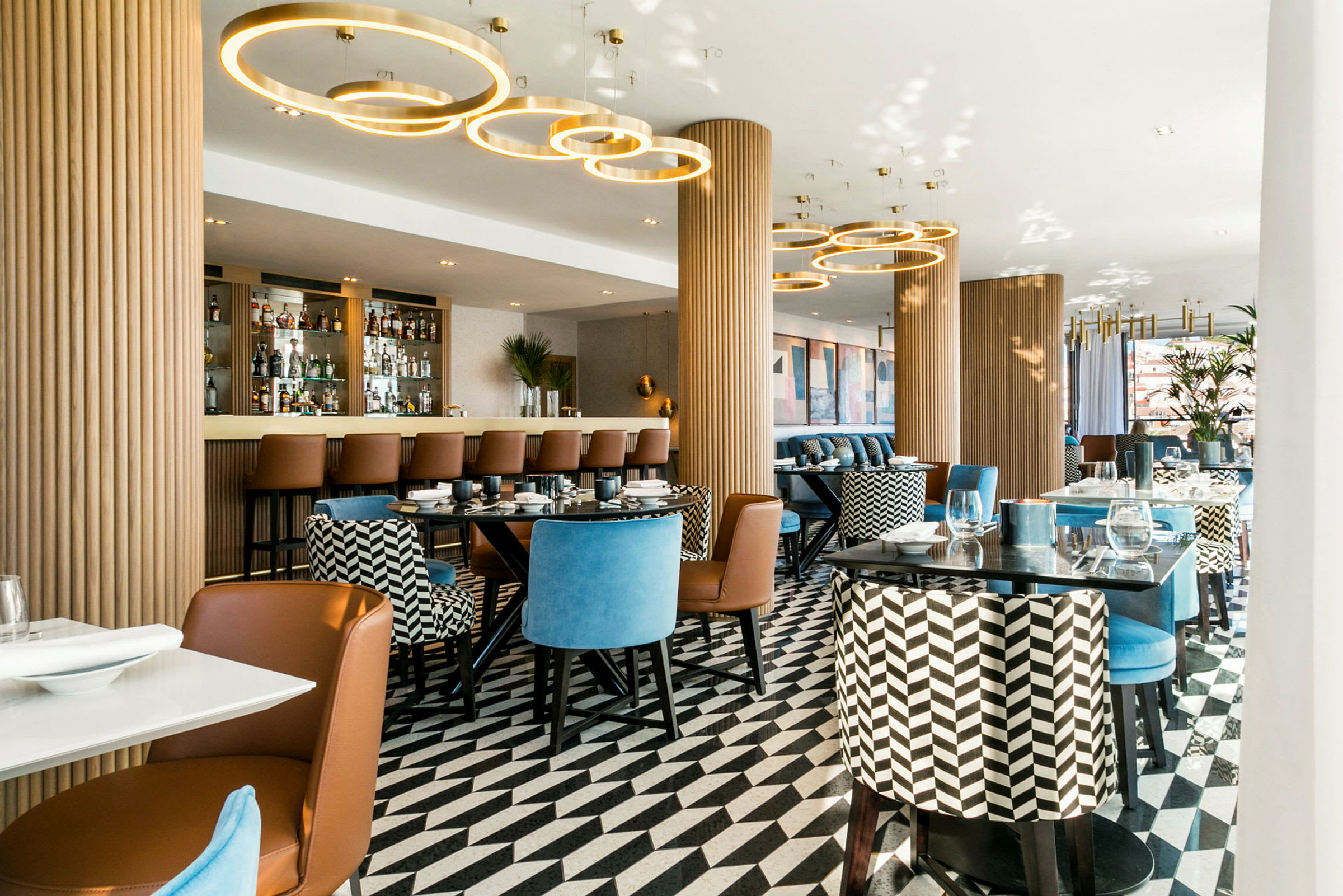 En elegant restaurant med moderne siddepladser, et mønstret gulv og en bardisk i baggrunden. (AI-genereret tekst)
