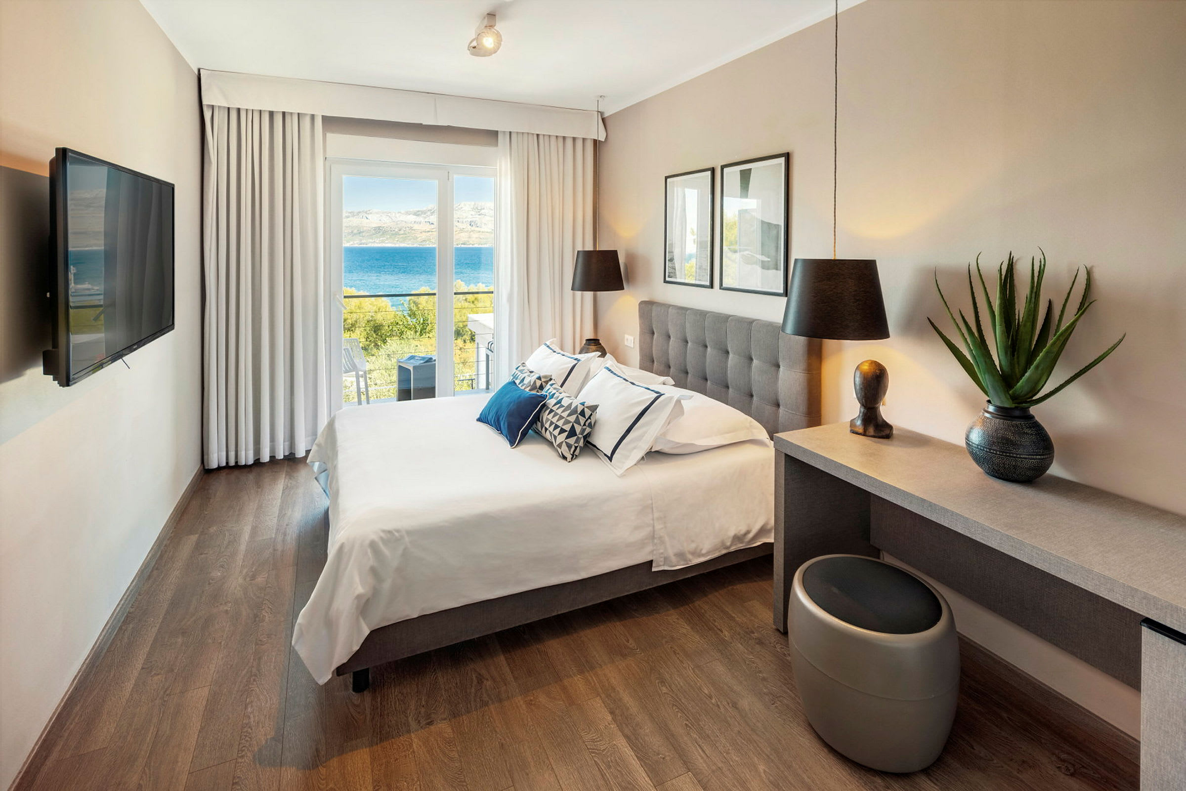 Hotelværelse med dobbeltseng og udsigt over havet. (AI-genereret tekst)