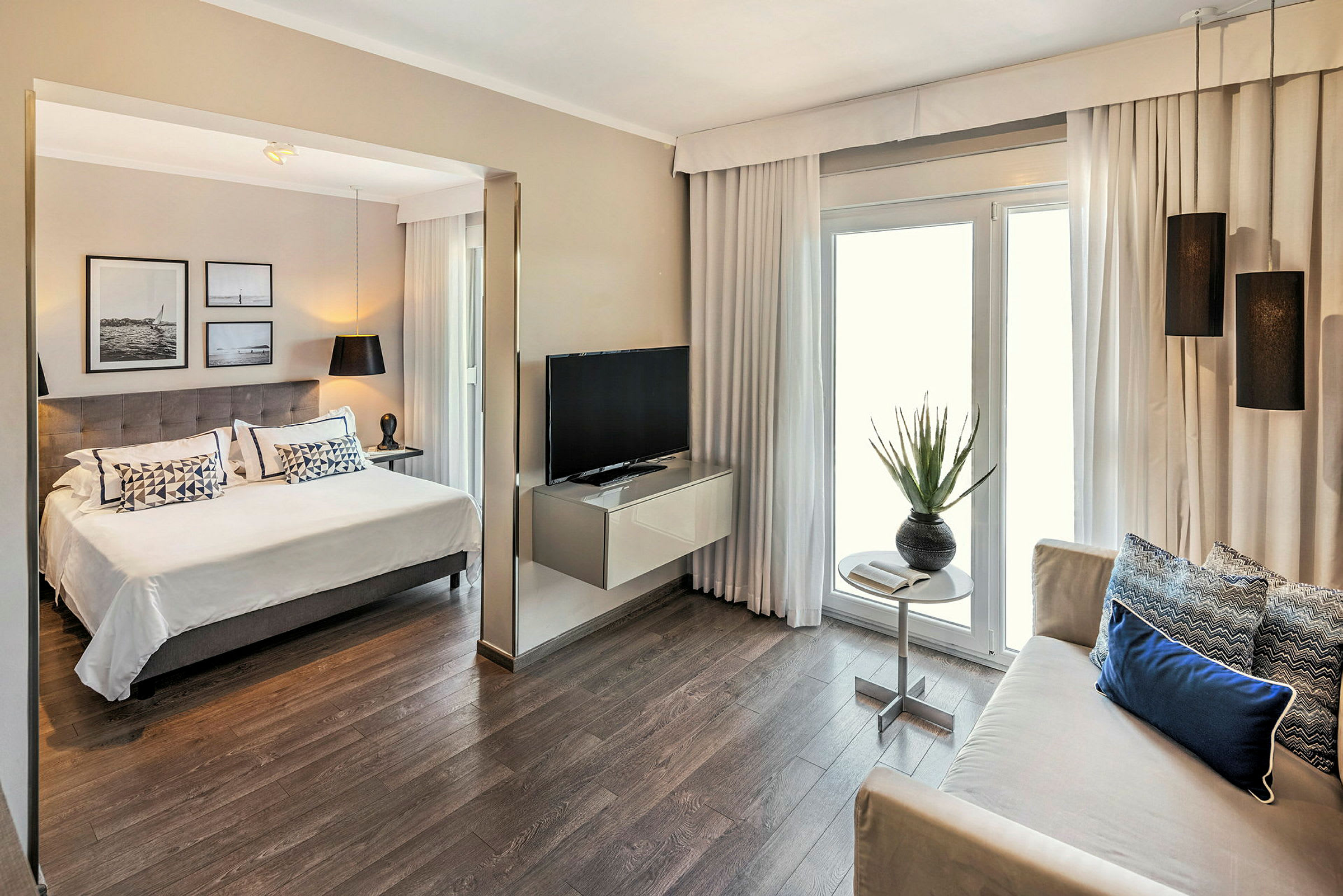 Billede af et moderne hotelværelse med en dobbeltseng, siddeområde, TV og indretningsdetaljer. (AI-genereret tekst)