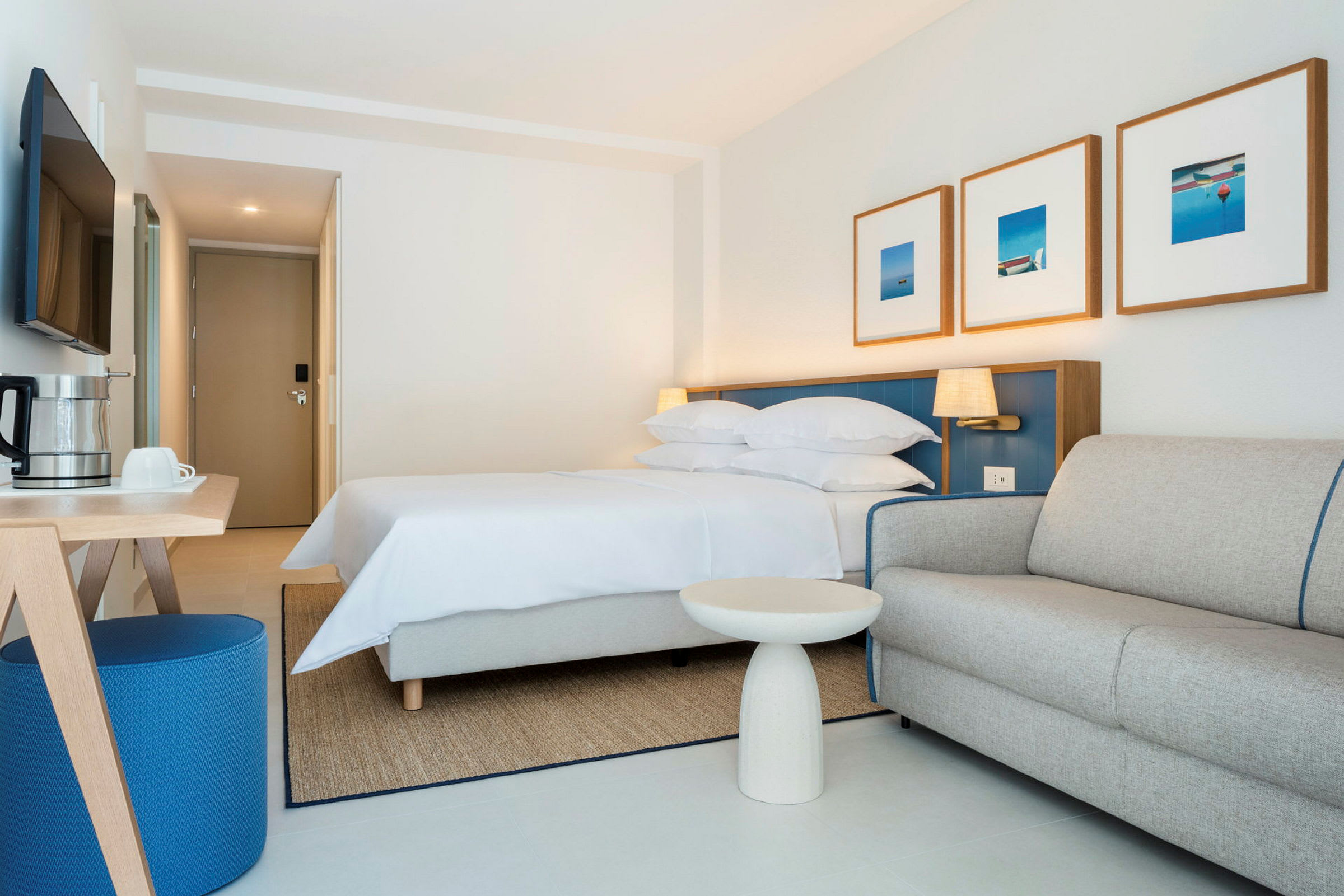 Hotelværelse med seng, sofa og bord. (AI-genereret tekst)