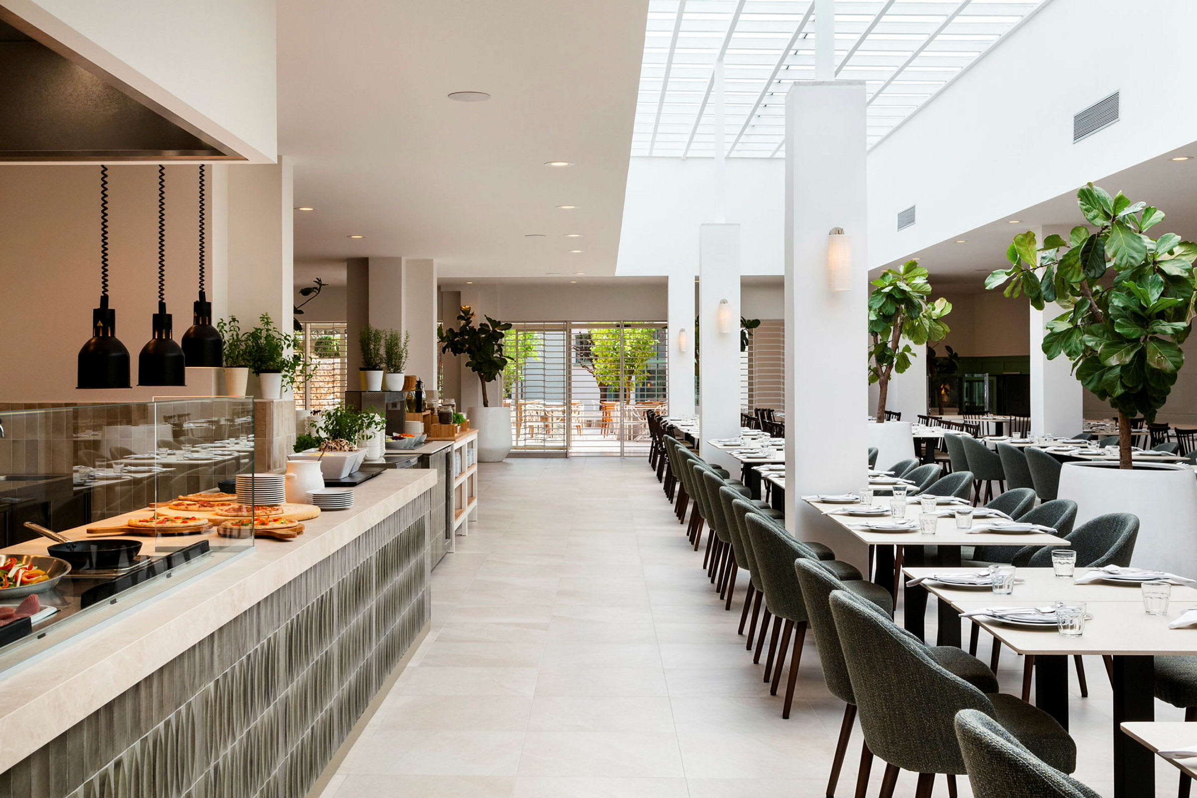 Lyst og moderne restaurantinteriør med spiseborde, stole og et serveringsområde. (AI-genereret tekst)