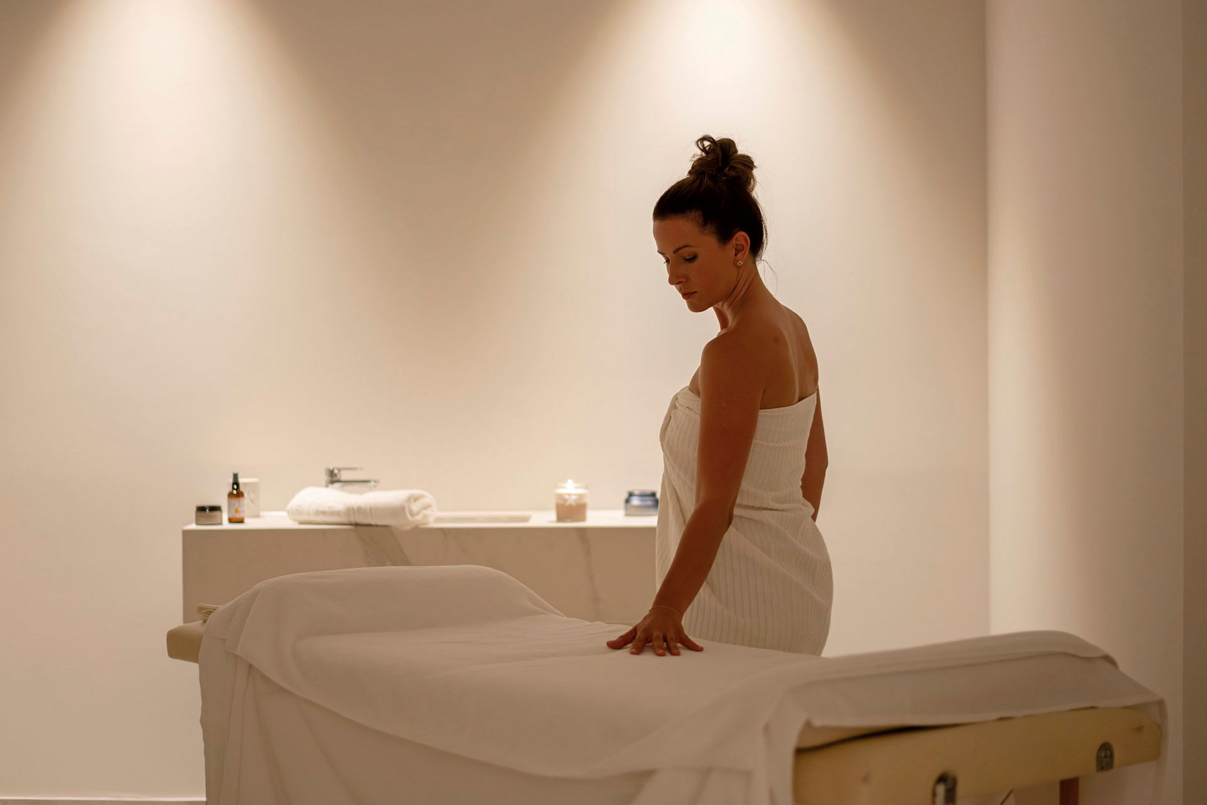 En person står ved en massagebænk i et spa. (AI-genereret tekst)