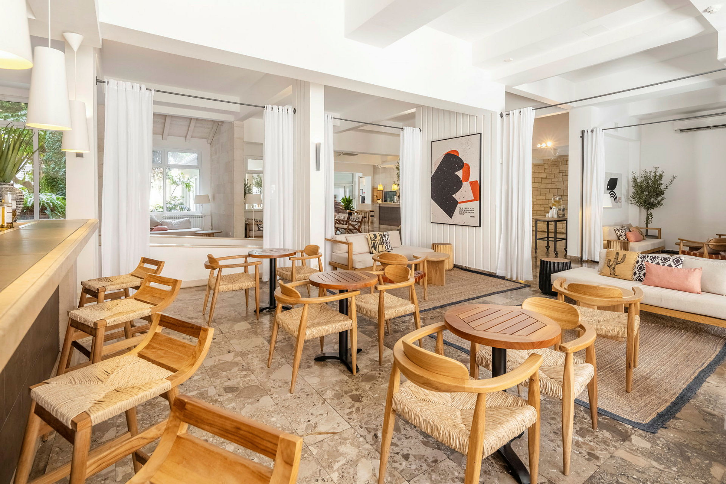 Lounge med træstole og borde, lyst og moderne indrettet. (AI-genereret tekst)