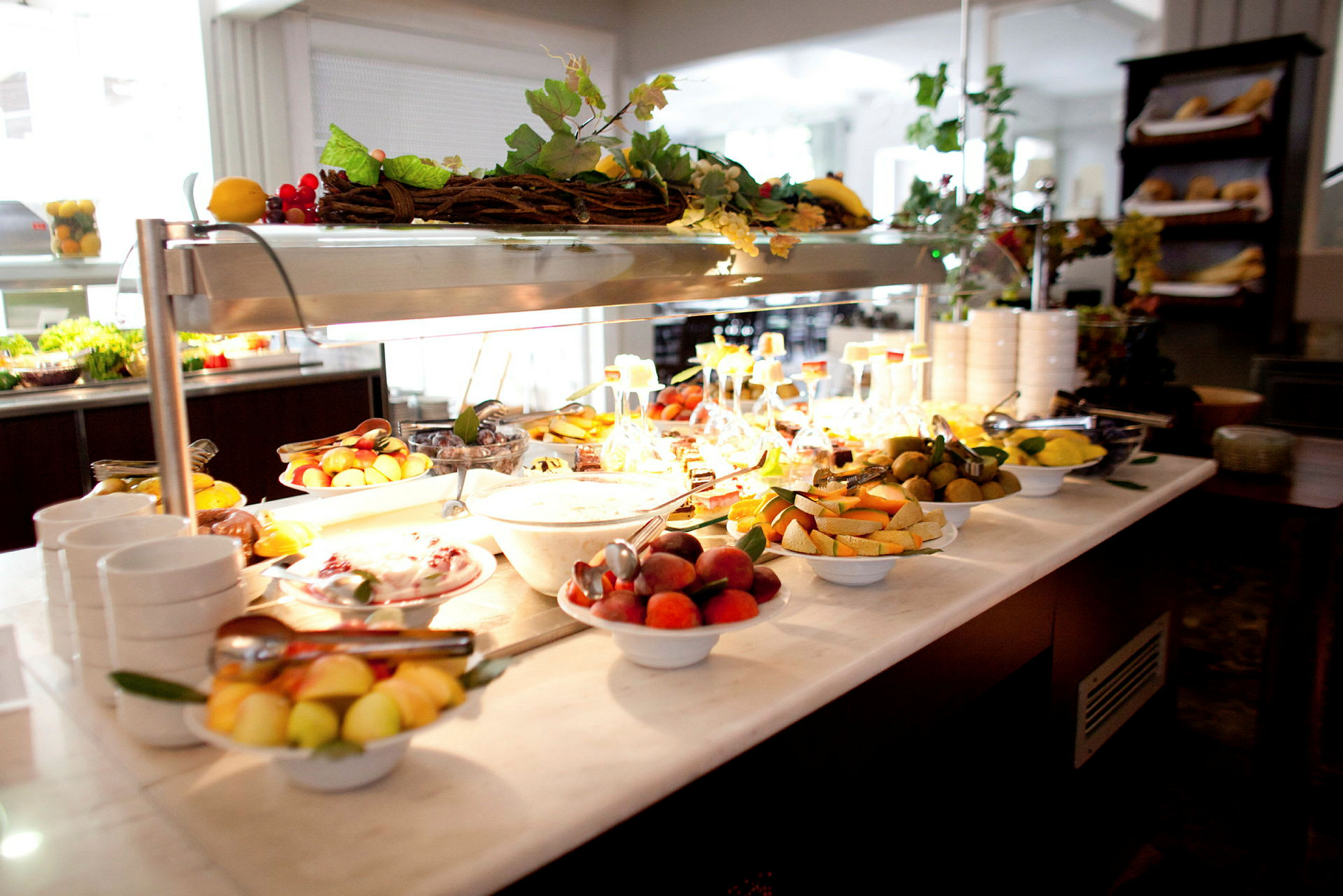 En buffet med friske frugter og yoghurt i en velbelyst spisestue. (AI-genereret tekst)