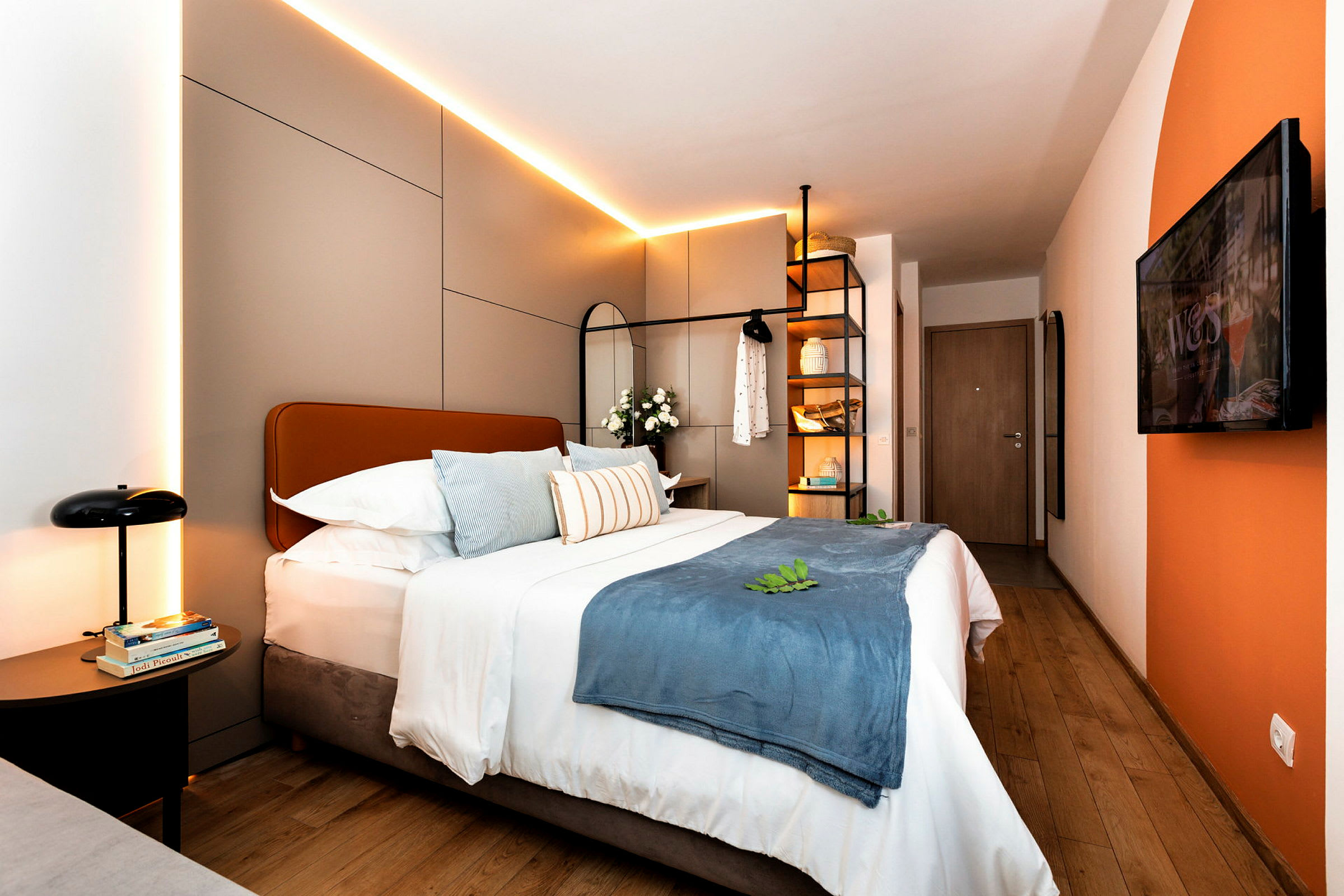 Moderne hotelværelse med dobbeltseng, dekorative puder og belysning. (AI-genereret tekst)