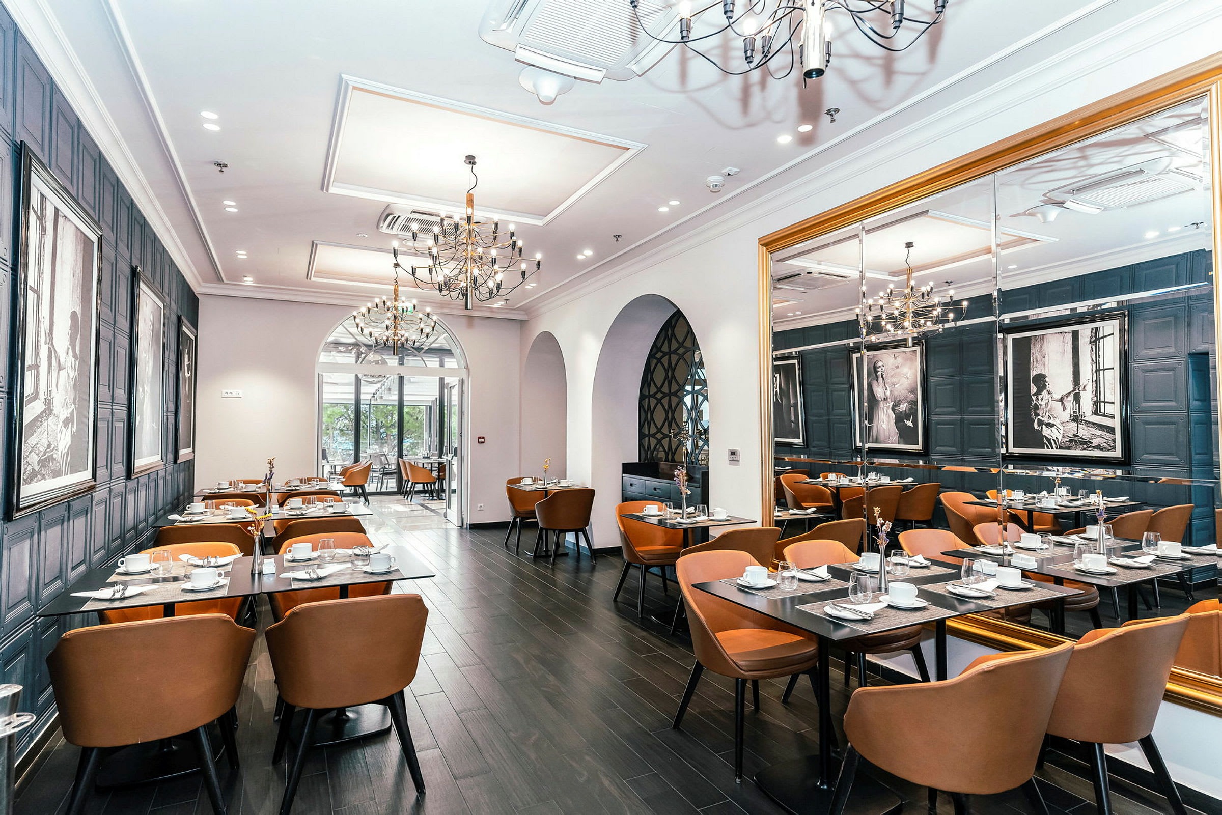Interiør af en elegant restaurant med borde og stole, dekoreret med kunst på væggene. (AI-genereret tekst)
