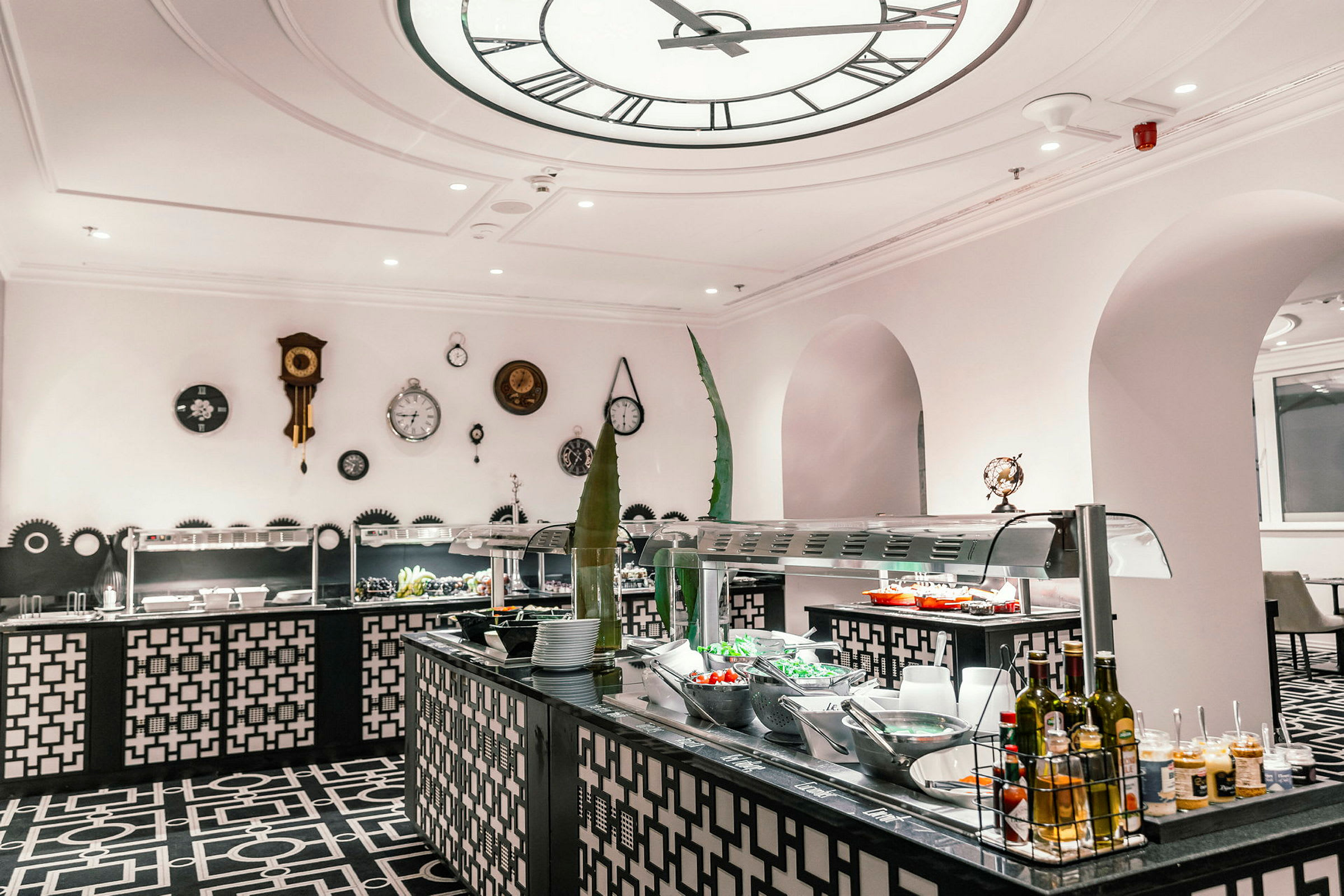 Et buffetområde i en restaurant med dekorativ indretning og borde, der serverer forskellige retter. (AI-genereret tekst)